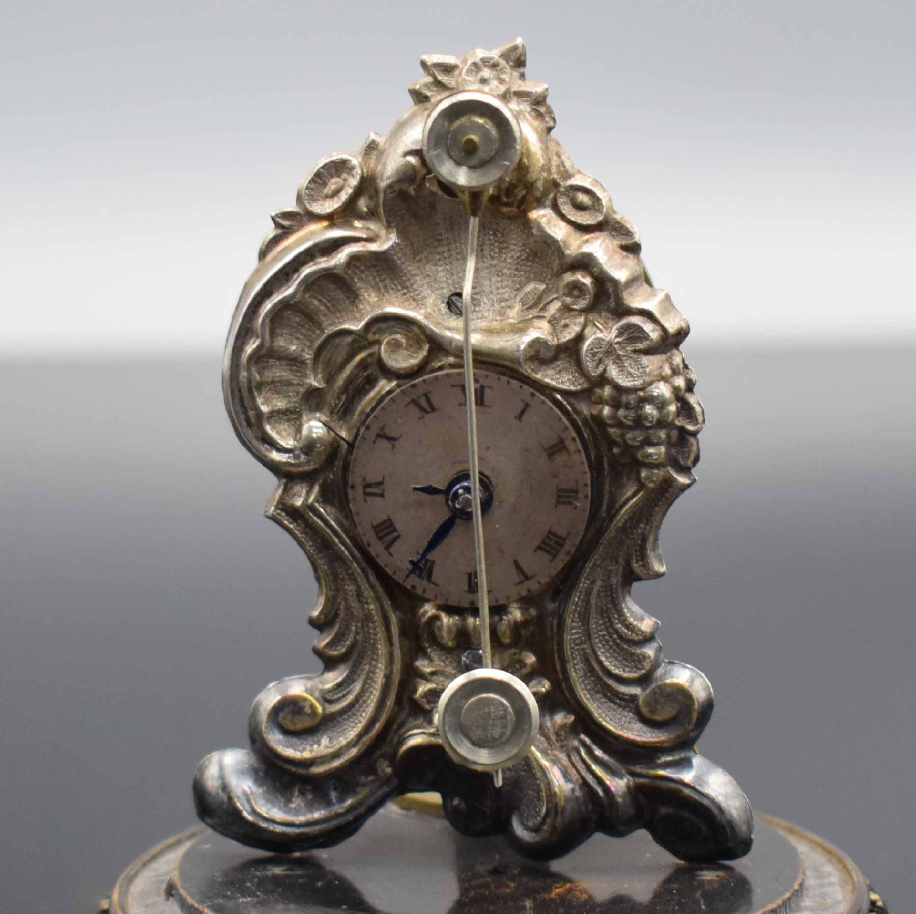 Detail e: Miniatur Vorderzappler unter Glasdom, Österreich um 1870, gedrechselter Holzsockel auf drei Füßen, vers. geprägte Front in Vasenform, ...