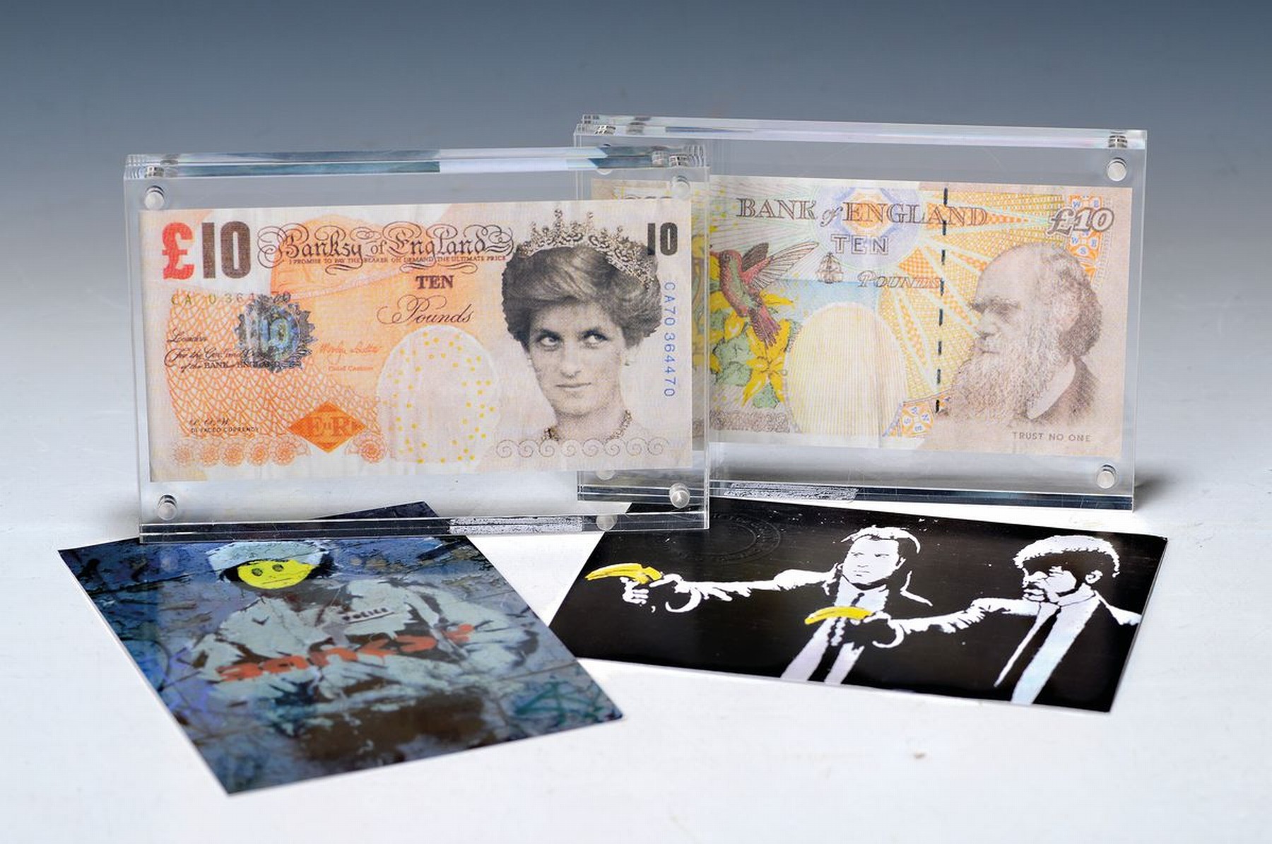 Banksy, geb. 1974, zeitgenössischer britischerStreet Art-Künstler, zwei Exemplare der die -faced Tenner, 10 Pfund-Note mit dem Bildnis Lady Dianas, ...