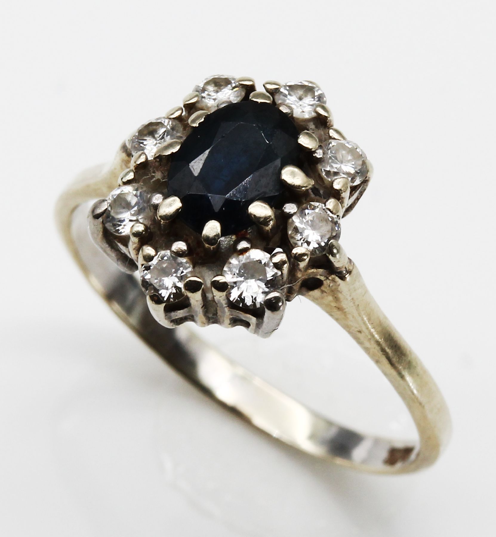 14 kt Gold Saphir-Diamant-Ring, WG 585/000,ovalfacett. Saphir ca. 1.0 ct, 7 Brillanten zus. ca. 0.35 ct Weiß/si und 1 Glasstein, total ca. 2.5 g, ...