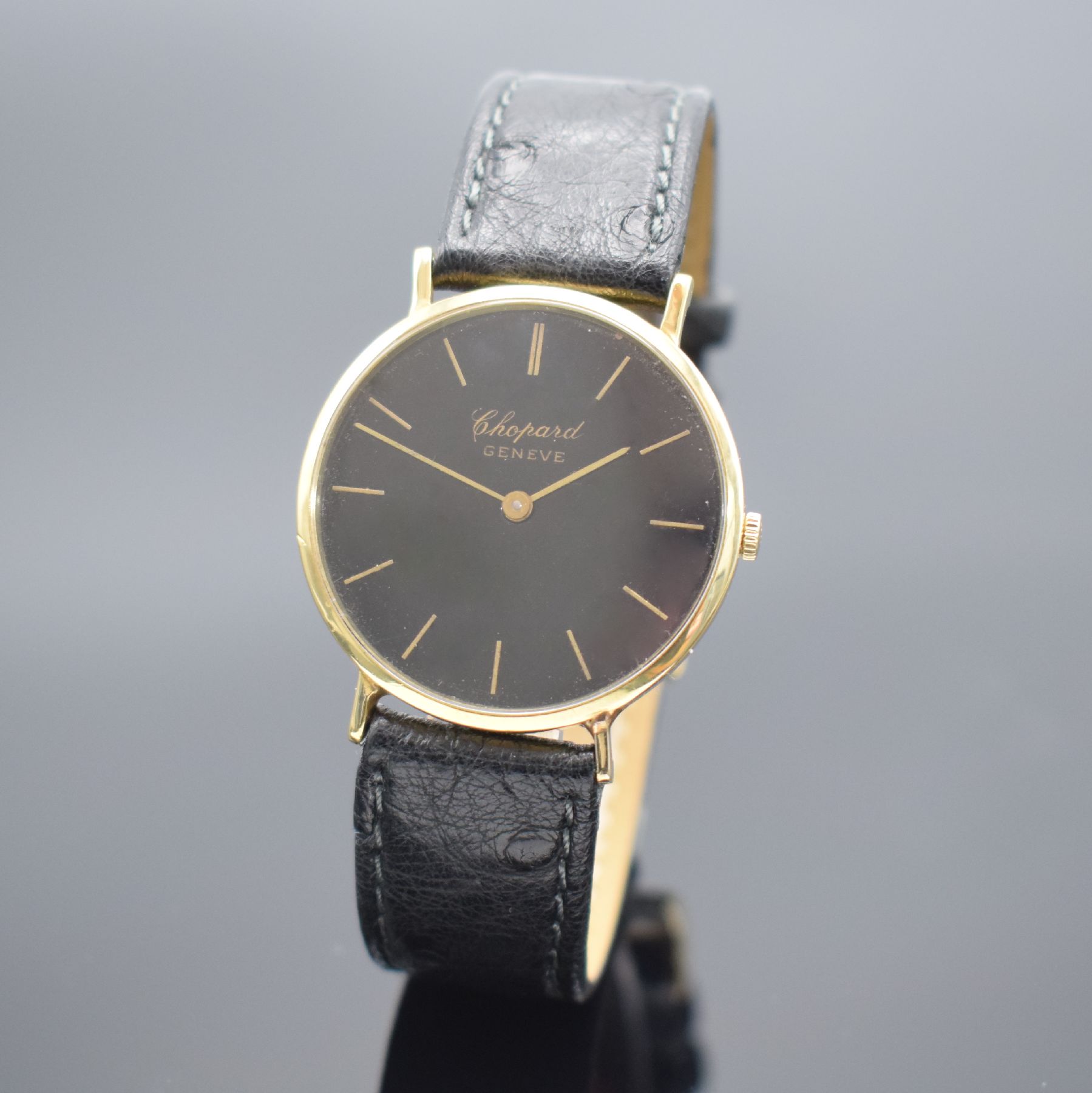 CHOPARD Armbanduhr in GG 750/000 Referenz 1013, Schweiz um 1990, Handaufzug, Boden aufgedr., schwarzes Zifferbl. rest., gold. Std.-Ind & gold. ...