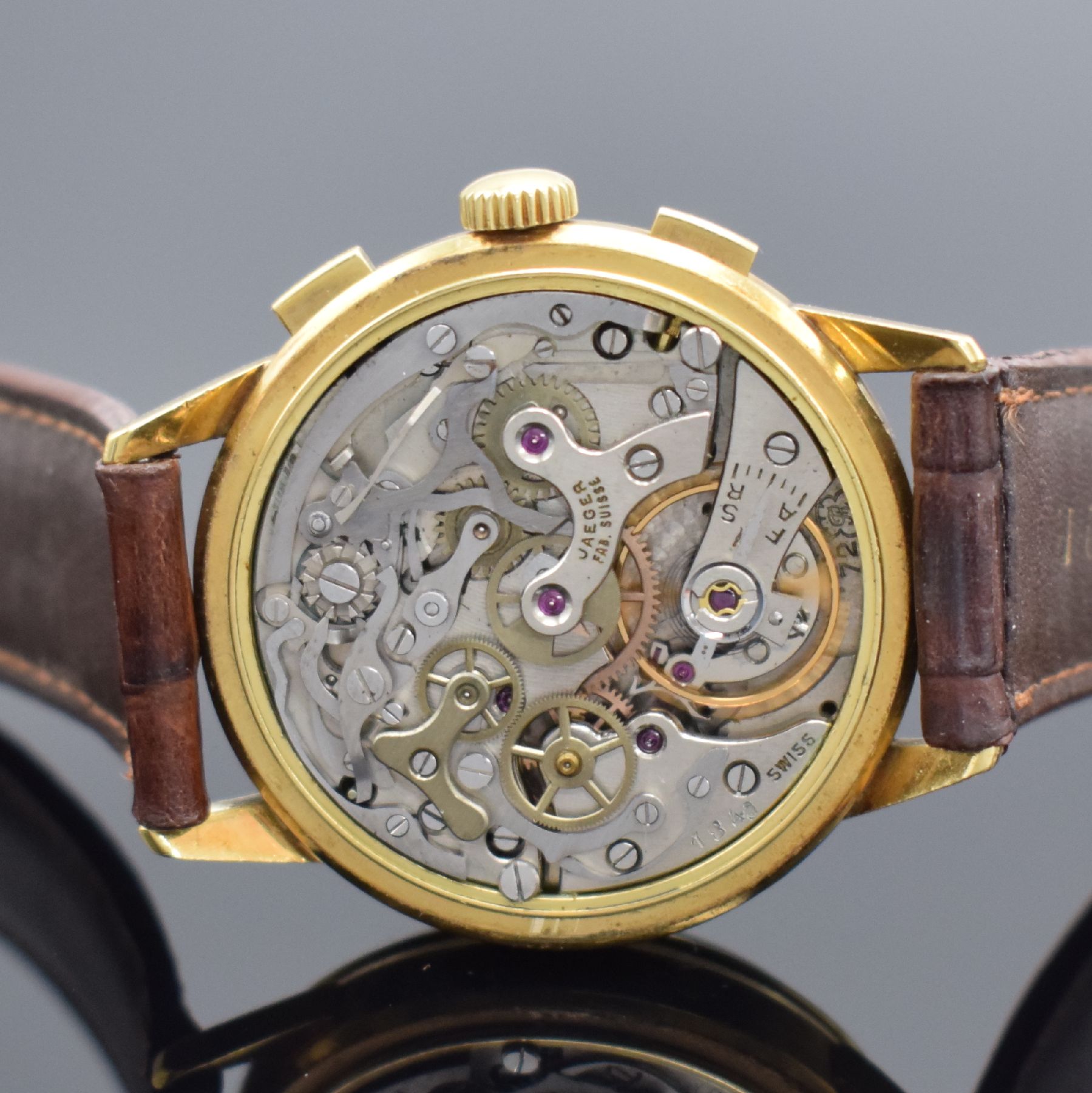 Detail d: JAEGER Herrenarmbanduhr mit Schaltradchronograph in GG 750/000, Schweiz 1960er Jahre, Handaufzug, Boden m. Widmung & Glasrand aufgedr., silb. ...