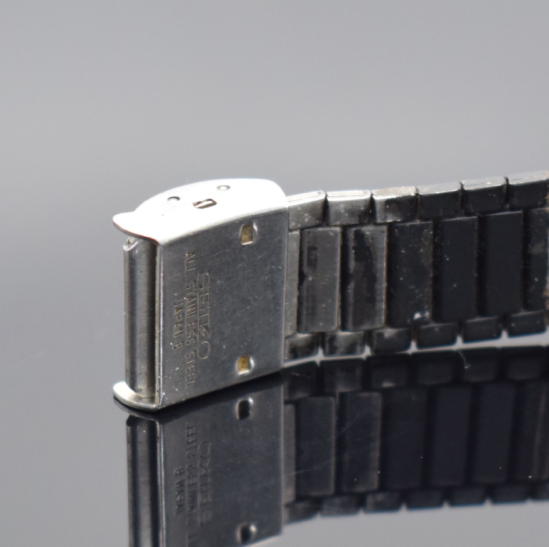 Detail b: SEIKO A159 Alarm Chronograph frühe Armbanduhr mit LCD-Anzeige in Stahl/Stahlband, Japan lt. Rechnungskopie verk. 11/1977, tonneau- förmiges Geh., ...