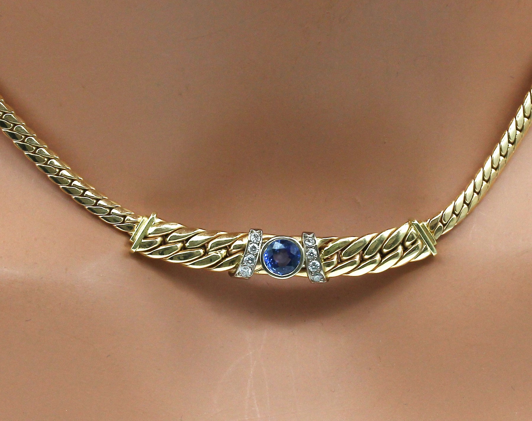 Detail b: 14 kt Gold Saphir-Brillant-Collier, GG 585/000 (gepr.), gedrückte Flachpanzerkette, Mittelteil mit rundfacett. Saphir ca. 0.85 ct und 8 Brillanten ...