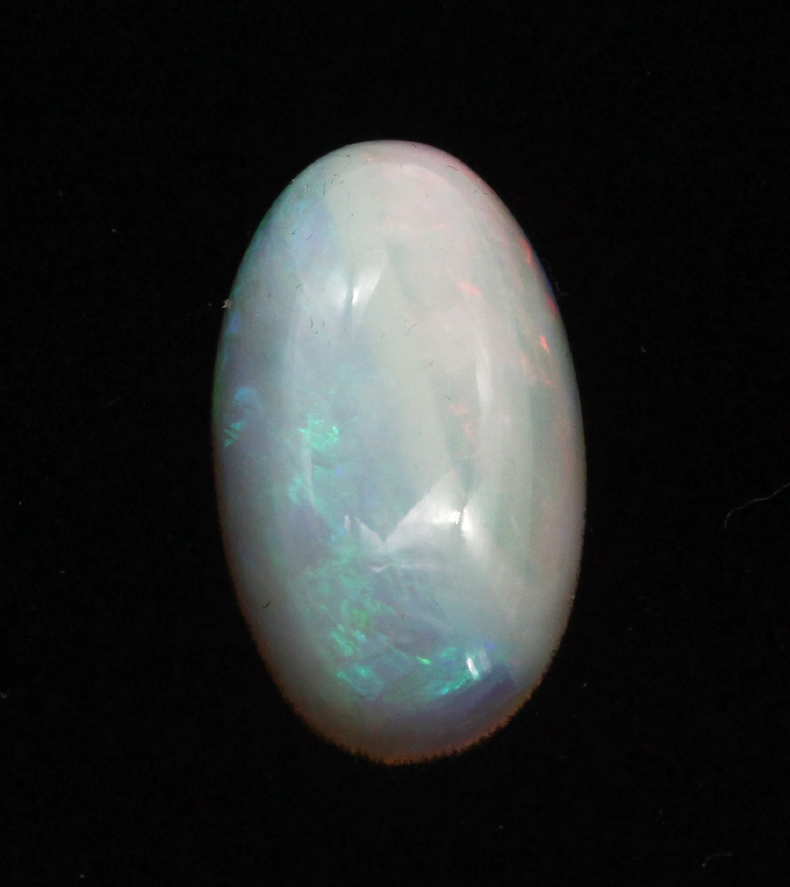 Detail a: Loser Opal-Cabochon, ca. 10.11 ct, länglichoval, Farbspiel in Gelb und Blau