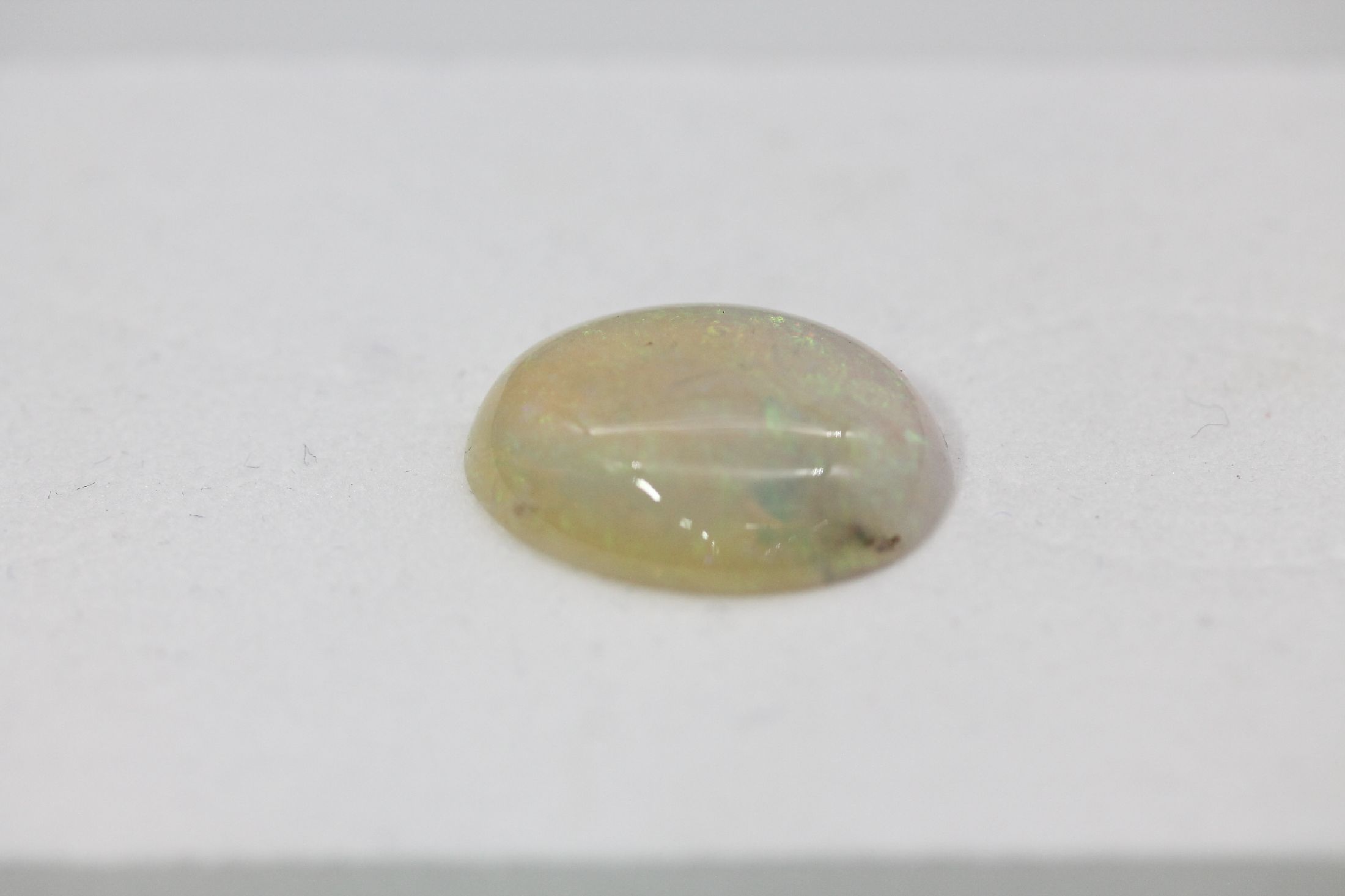 Detail c: Loser Opal-Cabochon, ca. 12.86 ct, oval , Farbspiel in Blau und Grün, min. besch.