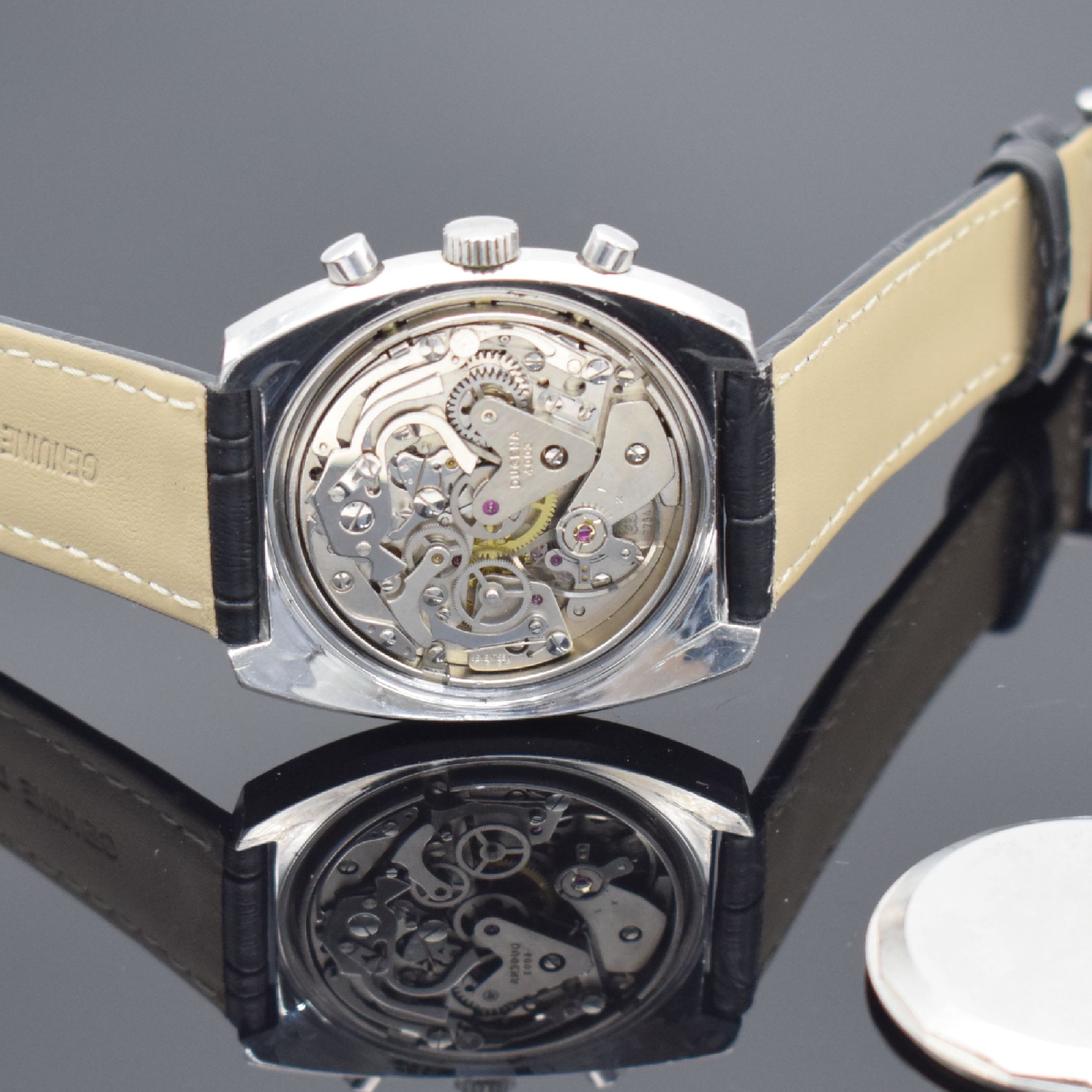 Detail d: DUGENA Herrenchronograph in Stahl, Schweiz um 1970, Handaufzug, unpoliertes verschr. Geh., schwarzes Zifferbl., weiße Hilfsblätter & ...