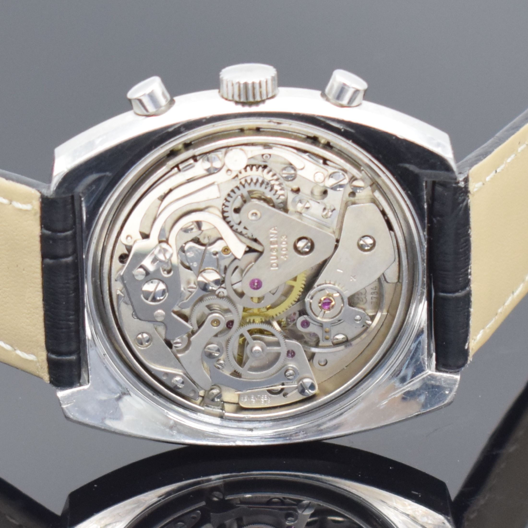 Detail e: DUGENA Herrenchronograph in Stahl, Schweiz um 1970, Handaufzug, unpoliertes verschr. Geh., schwarzes Zifferbl., weiße Hilfsblätter & ...