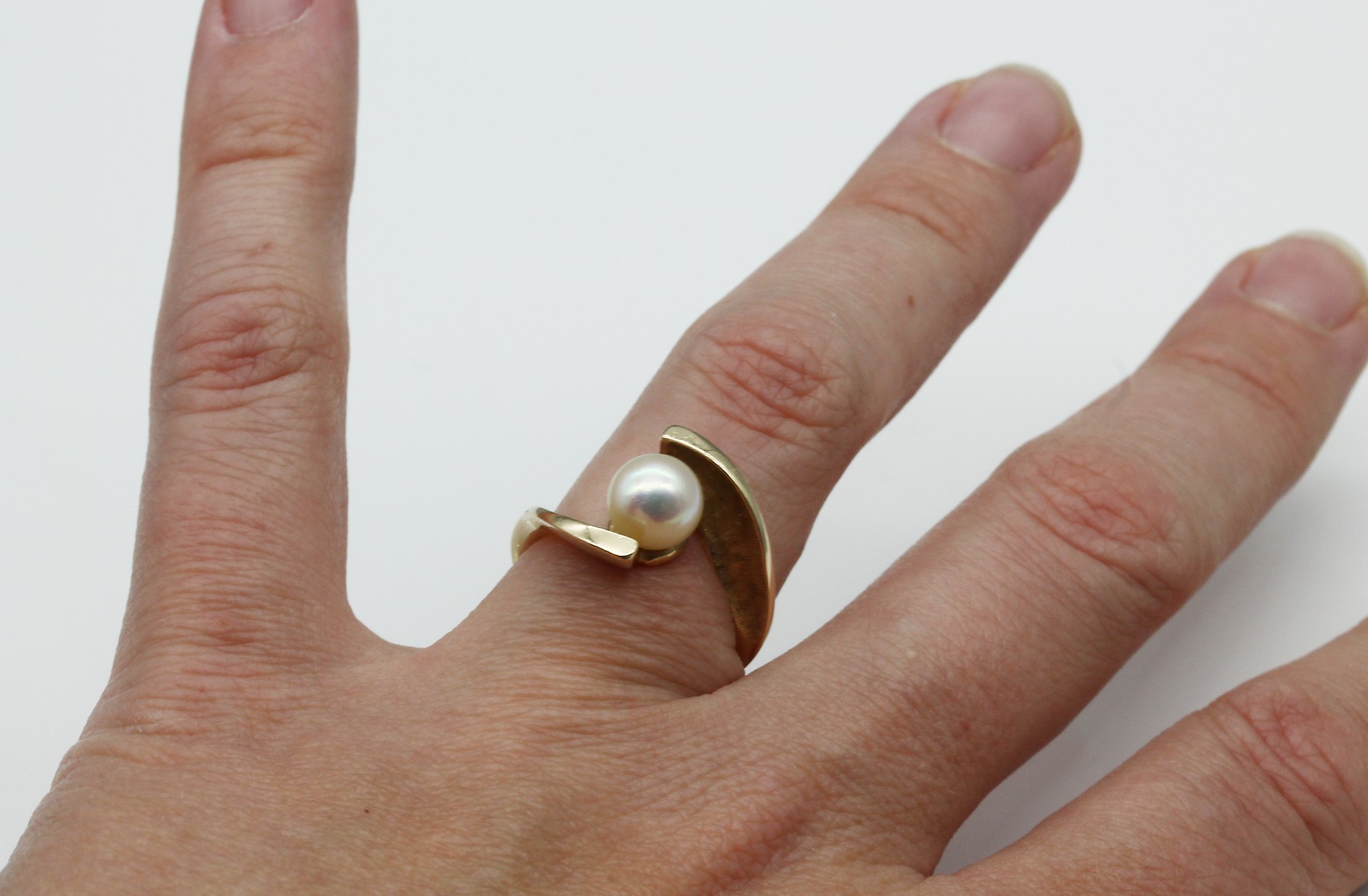 Detail b: 14 kt Gold Zuchtperl-Ring, ca. 4.1 g, GG 585/000, asymm. Schiene z.T. sat., mittige Akoyaperle, D. ca. 7.4 mm, RW 55, Meistermarke unged.