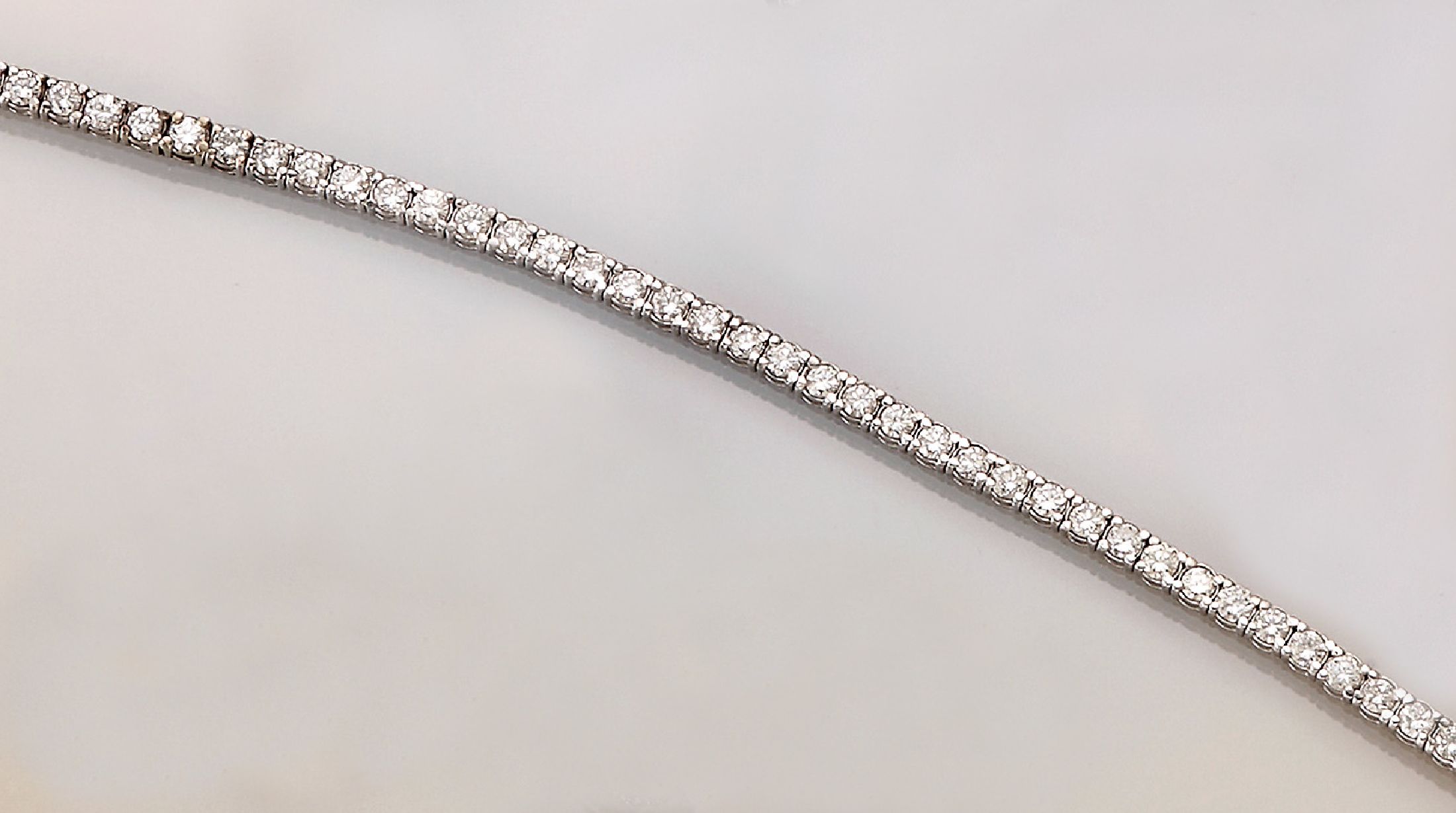 14 kt Gold Brillant-Linienarmband, WG 585/000, 62 einzeln gefasste Brillanten zus. ca. 3.20 ct Weiß/vs-si, L. ca. 18 cm, ca. 8.0 g, Kastenschloß ...