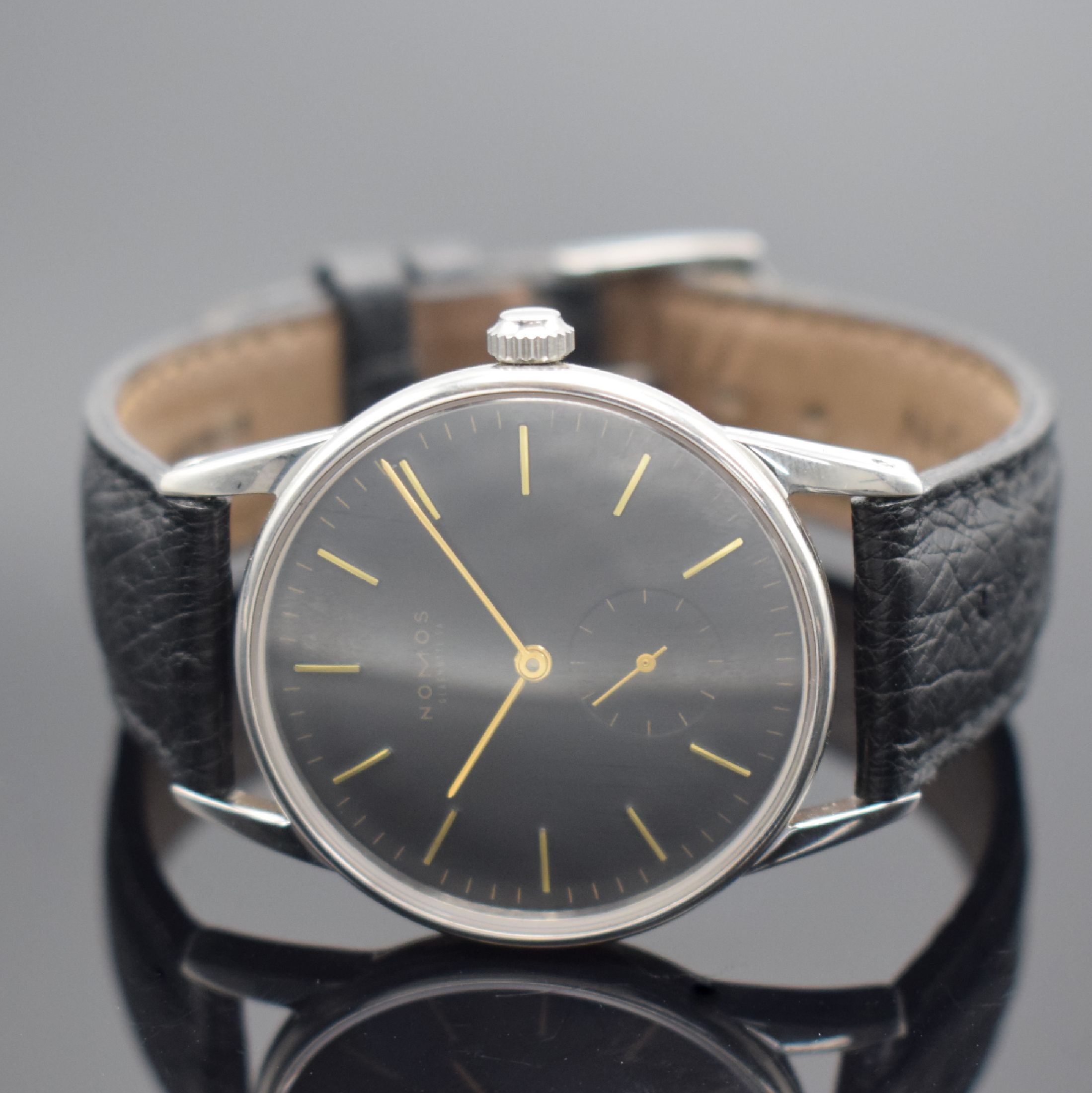 Detail b: NOMOS Herrenarmbanduhr Orion, Handaufzug, 3 -teil. Edelstahlgeh., Boden & Glasrand aufgedr., schwarzes Zifferbl. m. gold. Indizes, gold. Zeiger, Anz. ...