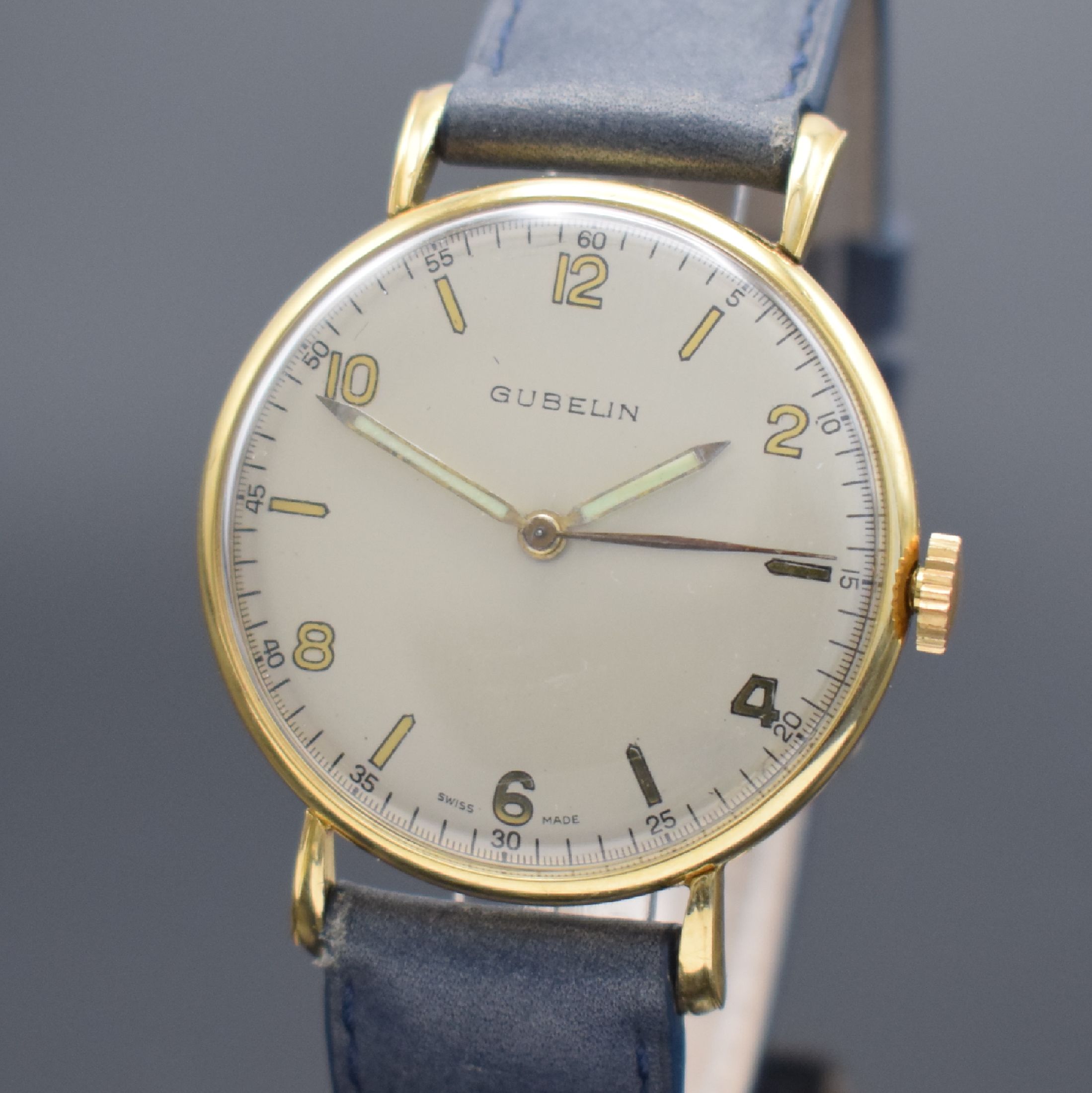 Detail a: GÜBELIN Armbanduhr in GG 750/000, Handaufzug, Schweiz um 1955, 3-teil. Geh., Boden & Glasrand aufgedr., bet. Bandanst., silb. Zifferbl. rest., Anz. ...