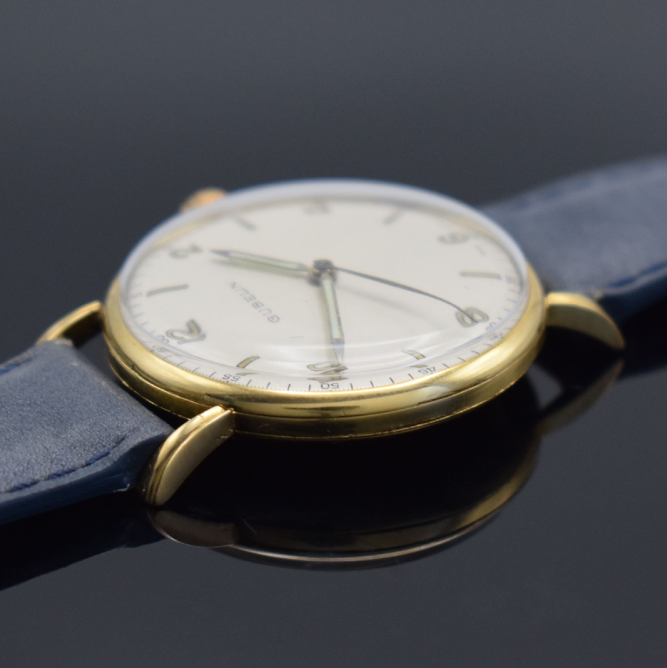 Detail b: GÜBELIN Armbanduhr in GG 750/000, Handaufzug, Schweiz um 1955, 3-teil. Geh., Boden & Glasrand aufgedr., bet. Bandanst., silb. Zifferbl. rest., Anz. ...