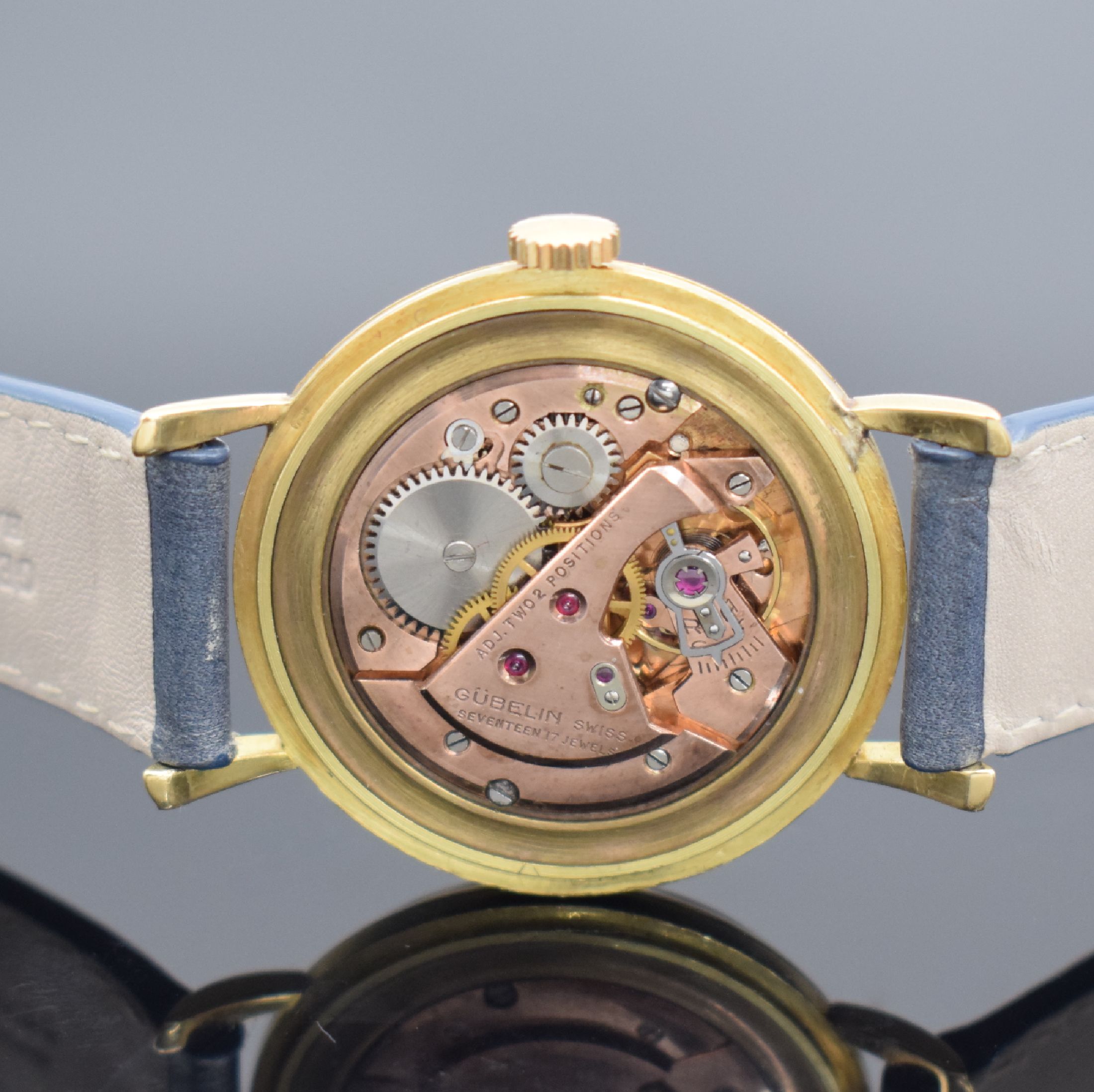 Detail c: GÜBELIN Armbanduhr in GG 750/000, Handaufzug, Schweiz um 1955, 3-teil. Geh., Boden & Glasrand aufgedr., bet. Bandanst., silb. Zifferbl. rest., Anz. ...