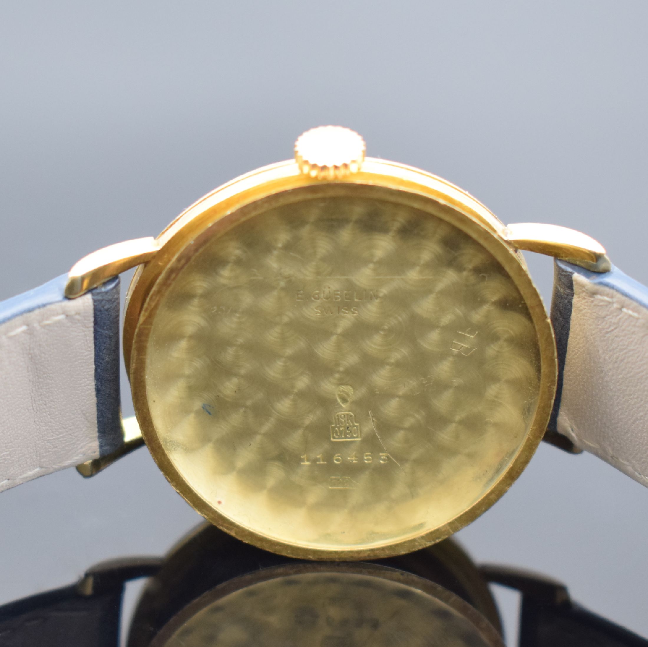 Detail d: GÜBELIN Armbanduhr in GG 750/000, Handaufzug, Schweiz um 1955, 3-teil. Geh., Boden & Glasrand aufgedr., bet. Bandanst., silb. Zifferbl. rest., Anz. ...