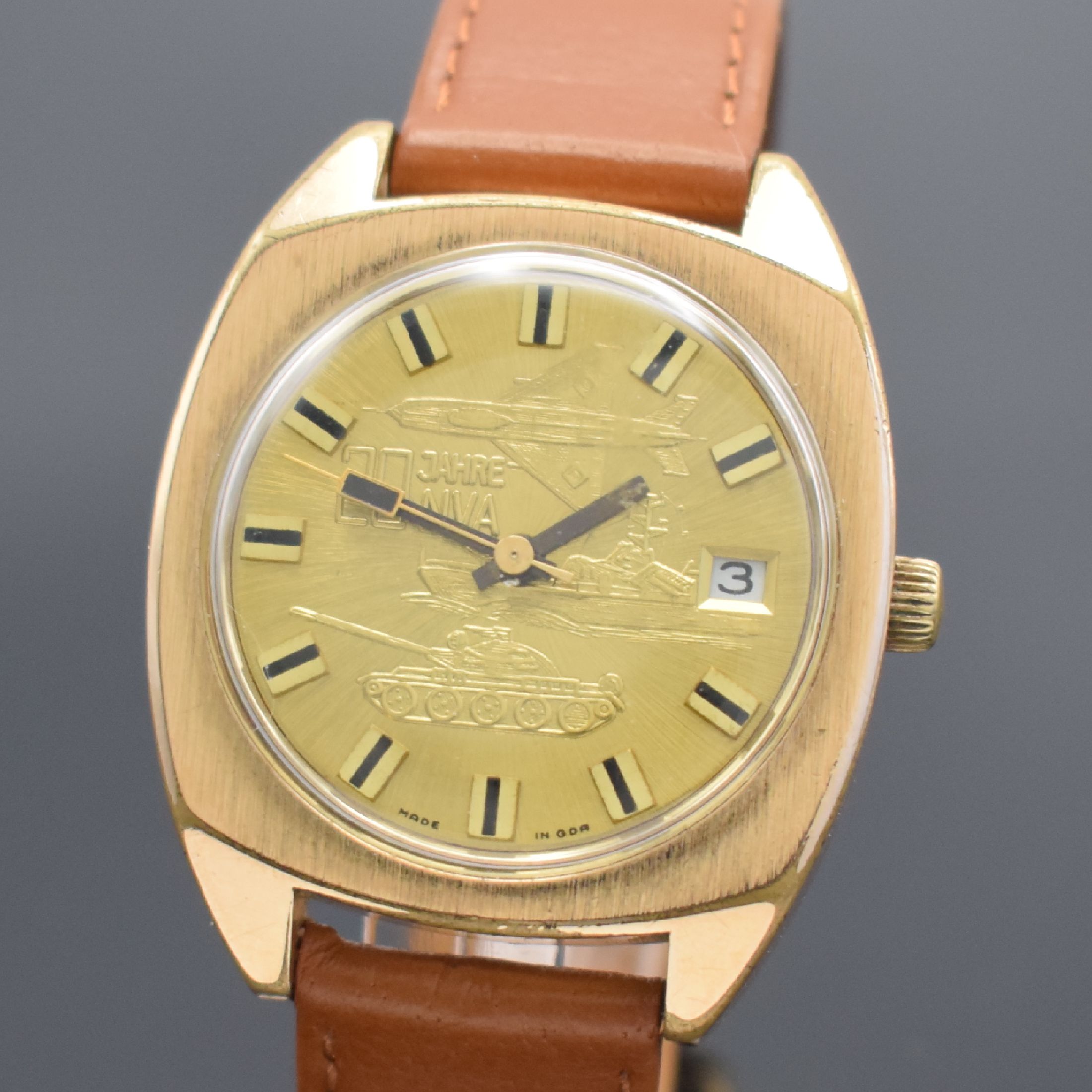 Detail a: GUB 20 Jahre NVA Herrenarmbanduhr, DDR um 1976, Automatik, verg. Gehäuse, Edelstahlboden aufgedr., gold. Zifferbl. m. Darst. der 3 Waffengattungen ...