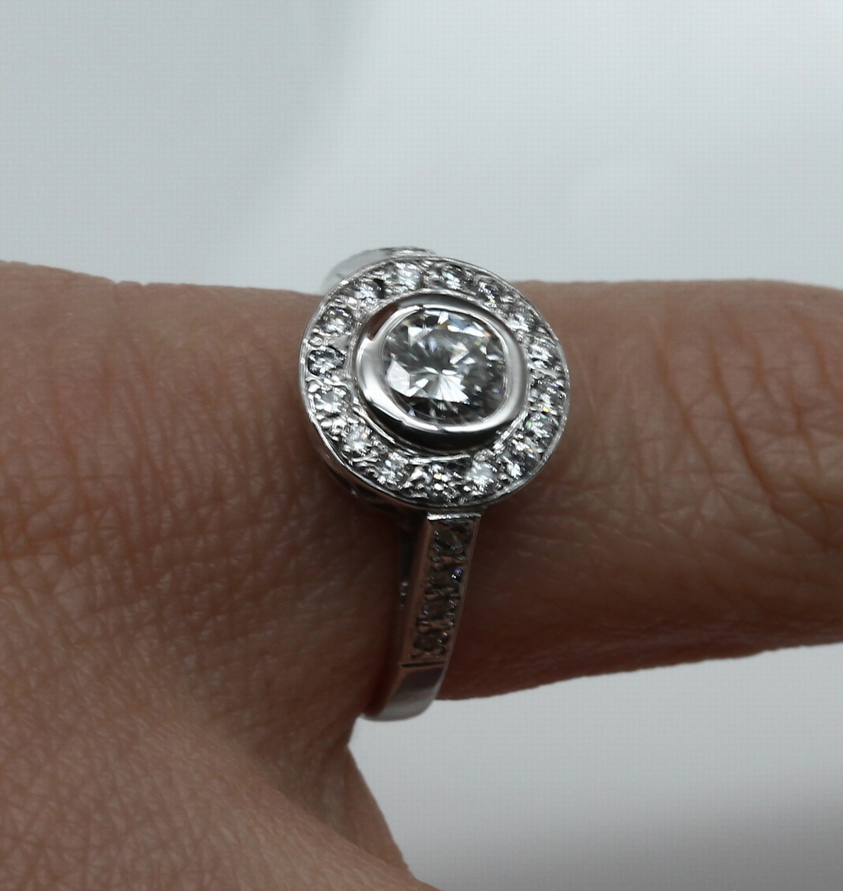 Detail a: 18 kt Gold Brillant-Ring, WG 750/000, 1 Brillant ca. 0.50 ct Weiß/vvs, umgeben von 25 Brillanten zus. ca. 0.25 ct Weiß/vs, ca. 4.2 g, RW 51.5