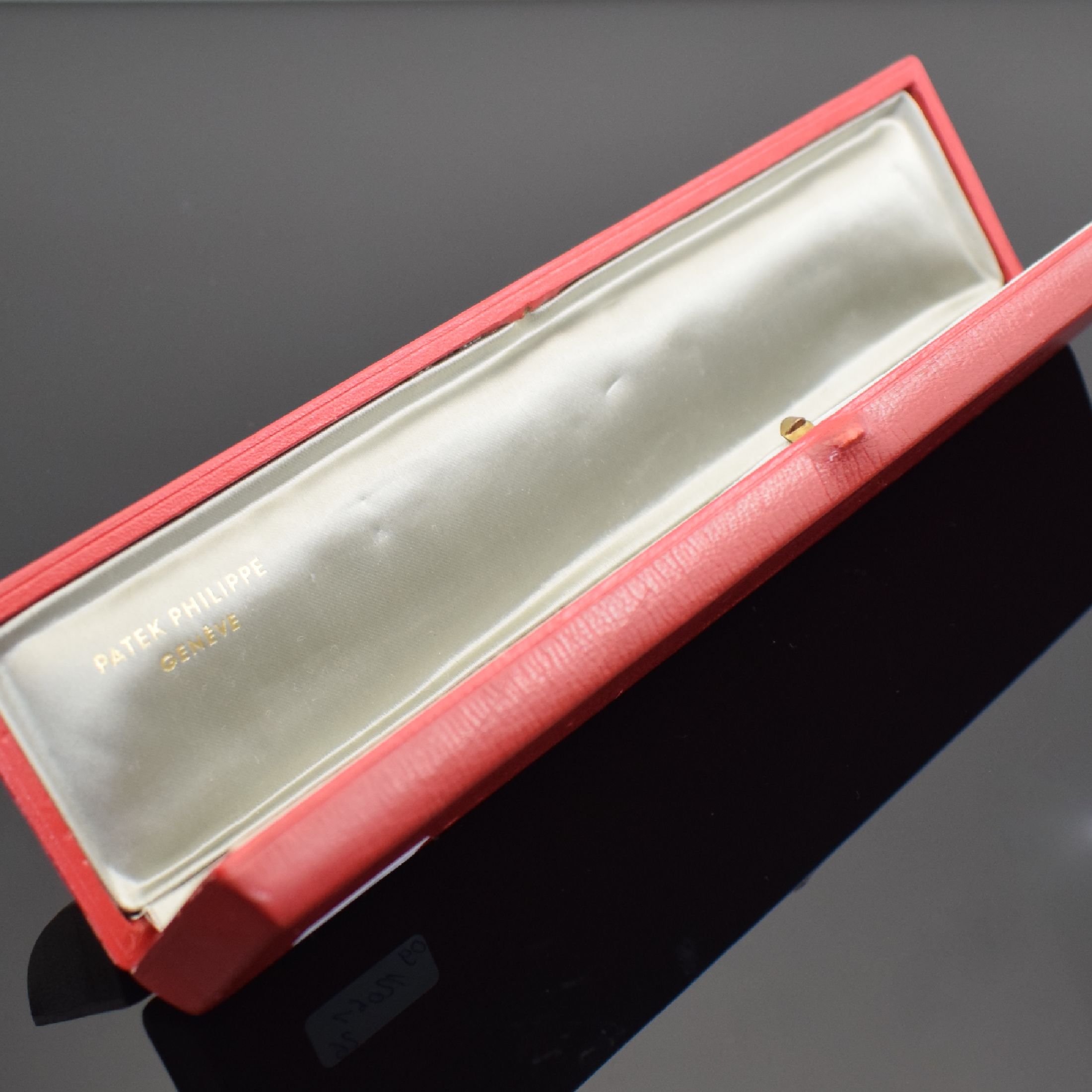 Detail b: PATEK PHILIPPE hochwertiges, pultförmiges Armbanduhr-Etui, Schweiz um 1960, außen rot, Deckel mit zentral aufgel. Calatrava Kreuz, innen ...