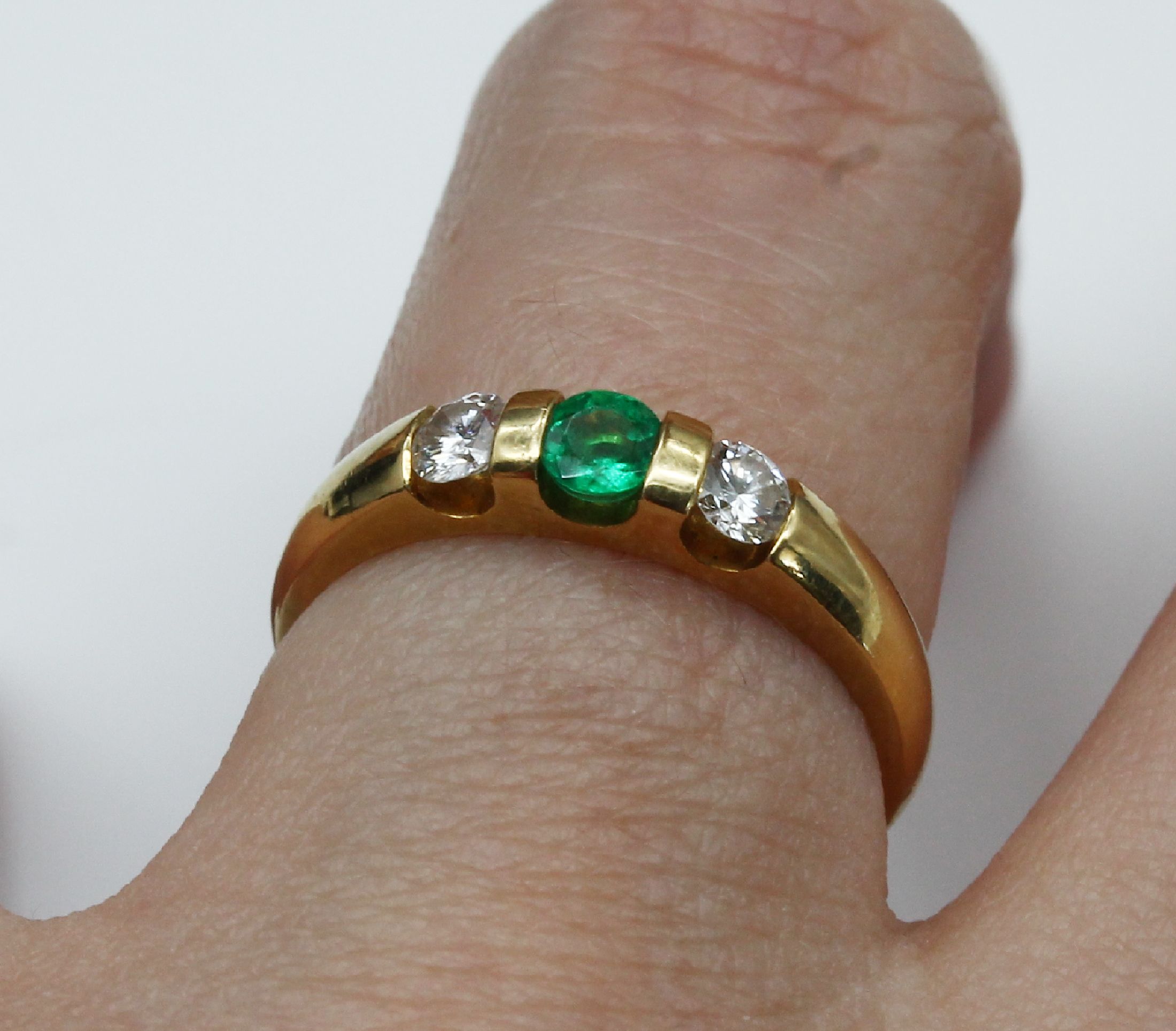 Detail a: 18 kt Gold Brillant-Smaragd-Ring, GG 750/000, mittig rundfacett. Smaragd ca. 0.21 ct, 2 Brillanten zus. ca. 0.27 ct feines Weiß/vs (Angaben grav.), ...
