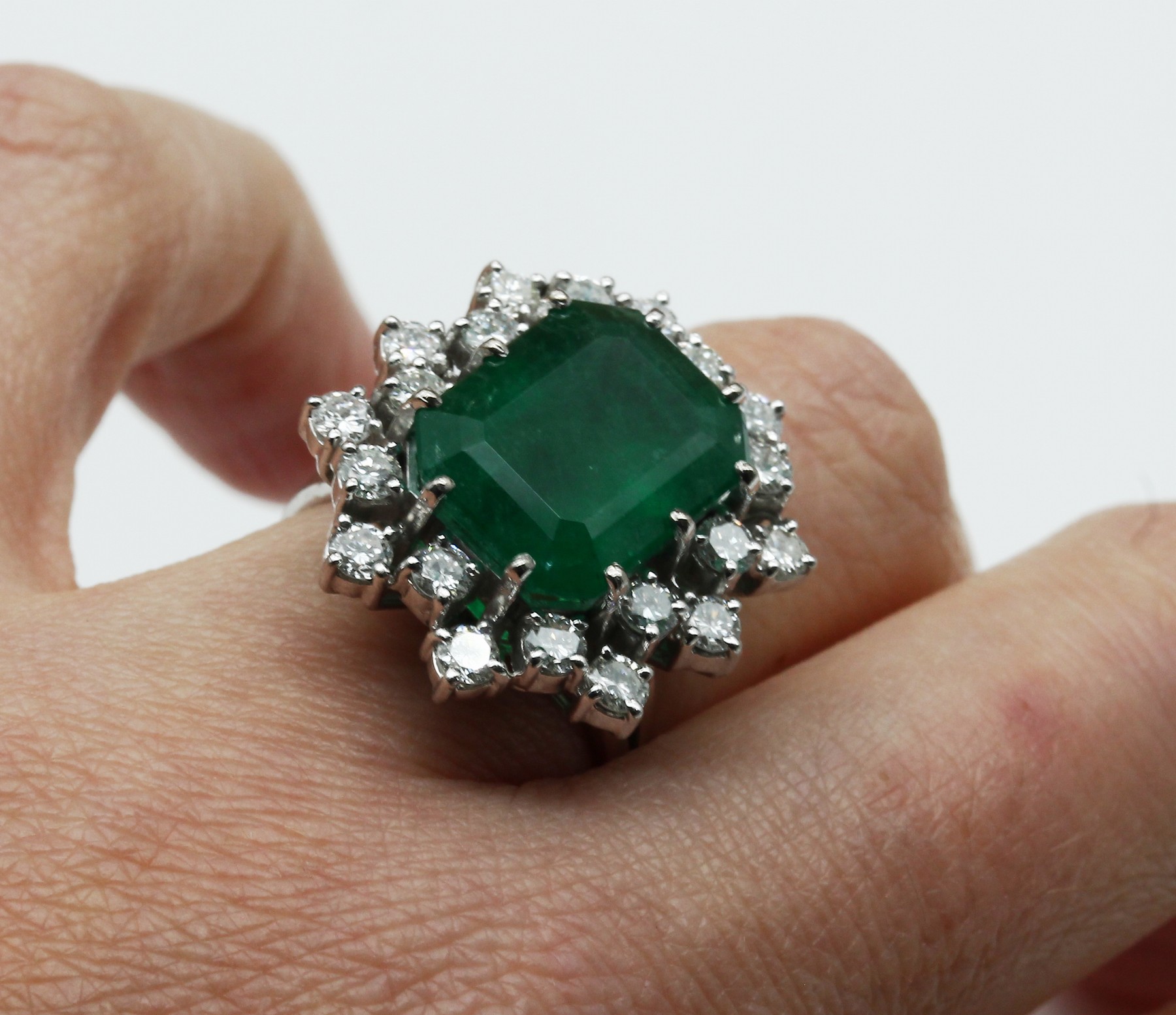 Detail a: 18 kt Gold Smaragd-Brillant-Ring, WG 750/000, mittig Smaragd im oktogonalen Treppenschliff ca. 8.20 ct, 20 Brillanten zus.ca. 1.60 ct feines ...