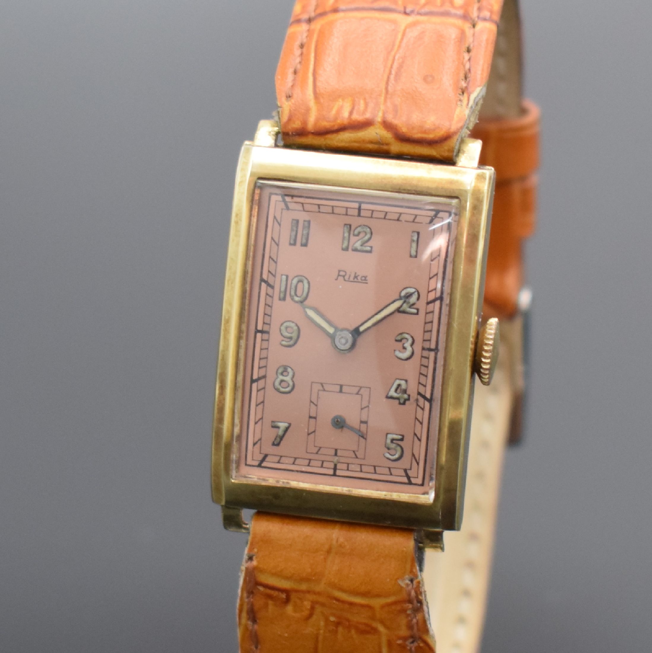 Detail a: RIKA Armbanduhr in GG 585/000, Handaufzug, Deutschland um 1940, Scharnierboden, rotverg. Zifferblatt m. arab. Leuchtzahlen l. fl., gebl. ...