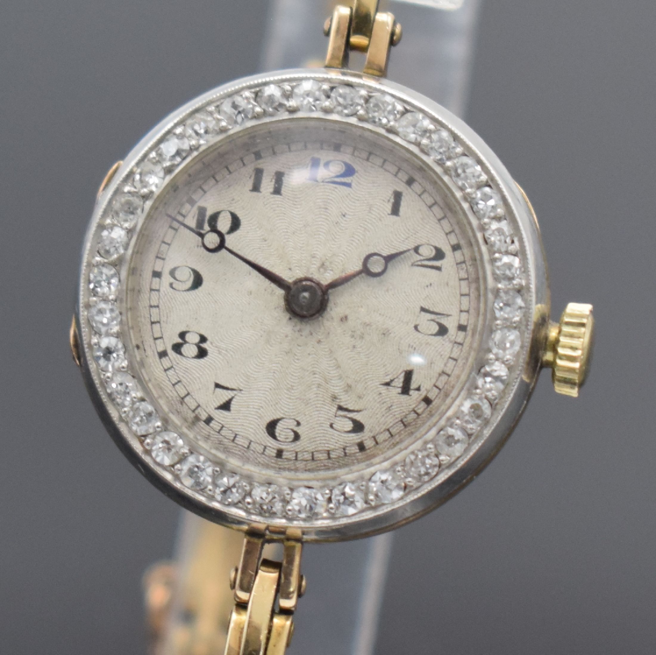 Detail a: Frühe Damenarmbanduhr in GG 585/000, Schweiz um 1920, Handaufzug, 3-teil. Geh., Goldband m. Sicherheitskettchen, Lünette in WG 333/000 m. Diamanten ...