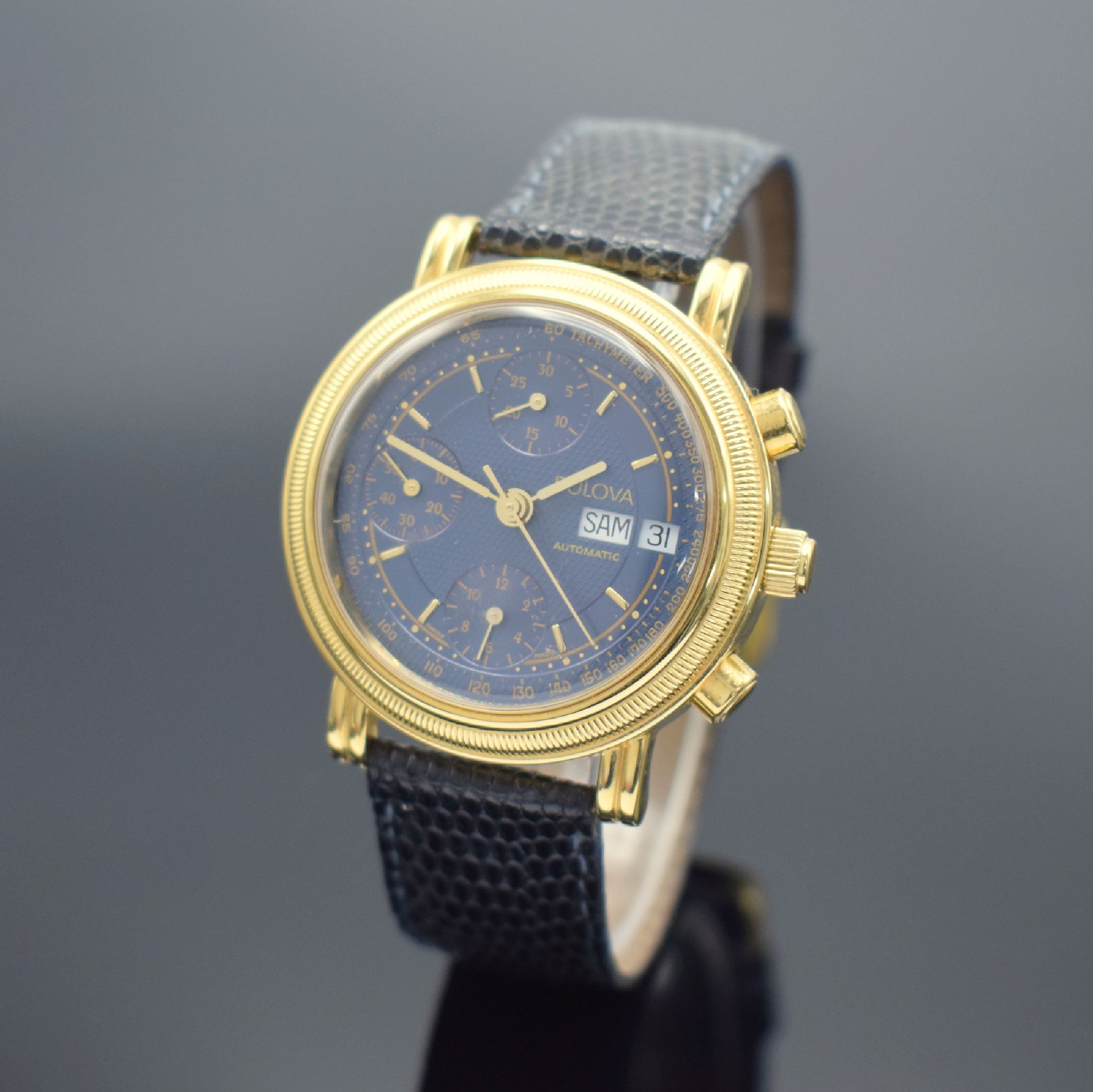 BULOVA Herrenarmbanduhr mit Chronograph, Schweiz um 1990, Automatik, 2-teil. verg. Geh., vergl. Boden aufgedr., dunkelblaues Zifferbl., gold. ...