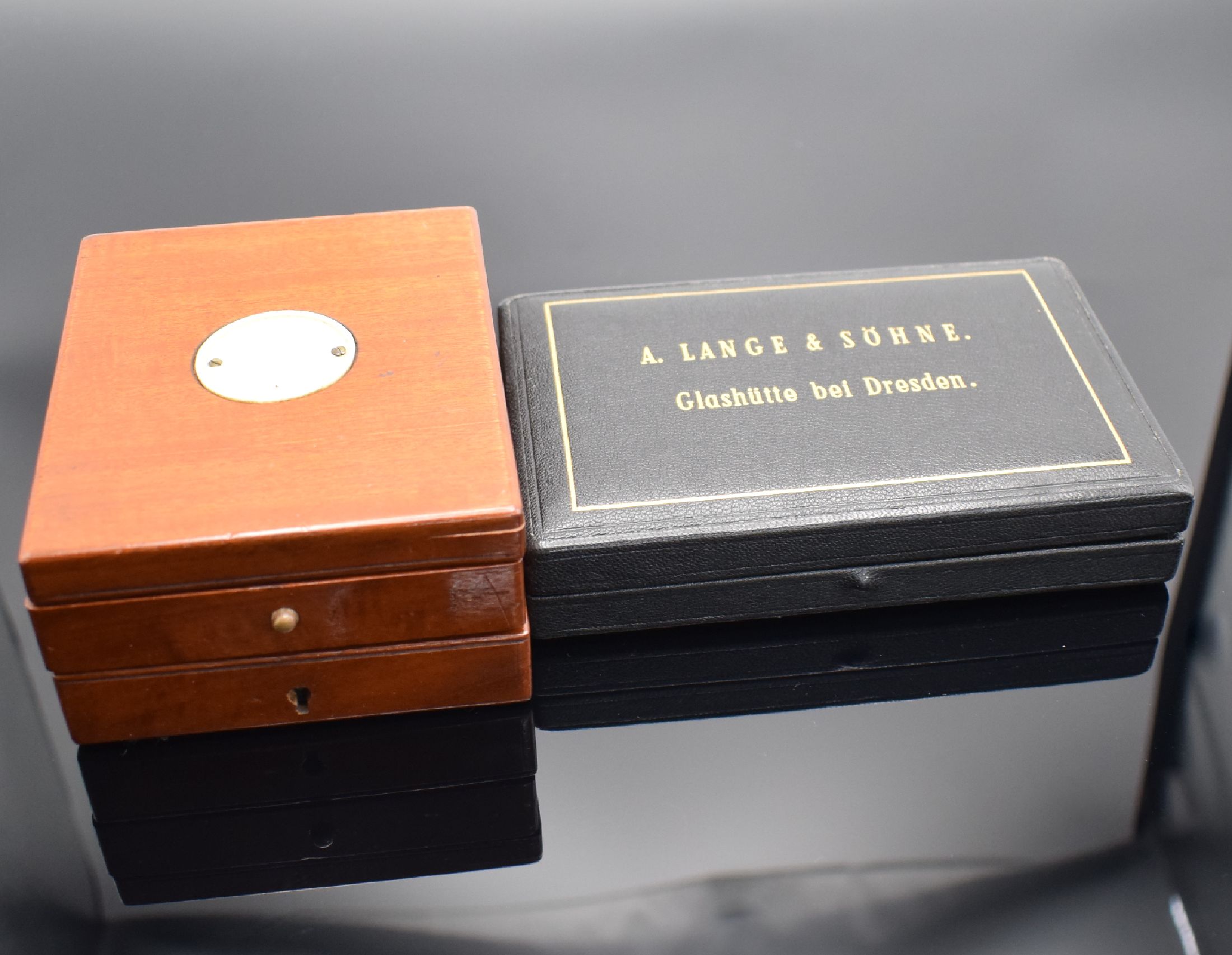 A. LANGE & SÖHNE Etui & Deckuhr-Holzbox, 1) modernes ALS-Etui m. Garantiekarte, 2) englische 3-teilige Mahagoni-Box, abschließbar, Schlüssel ...