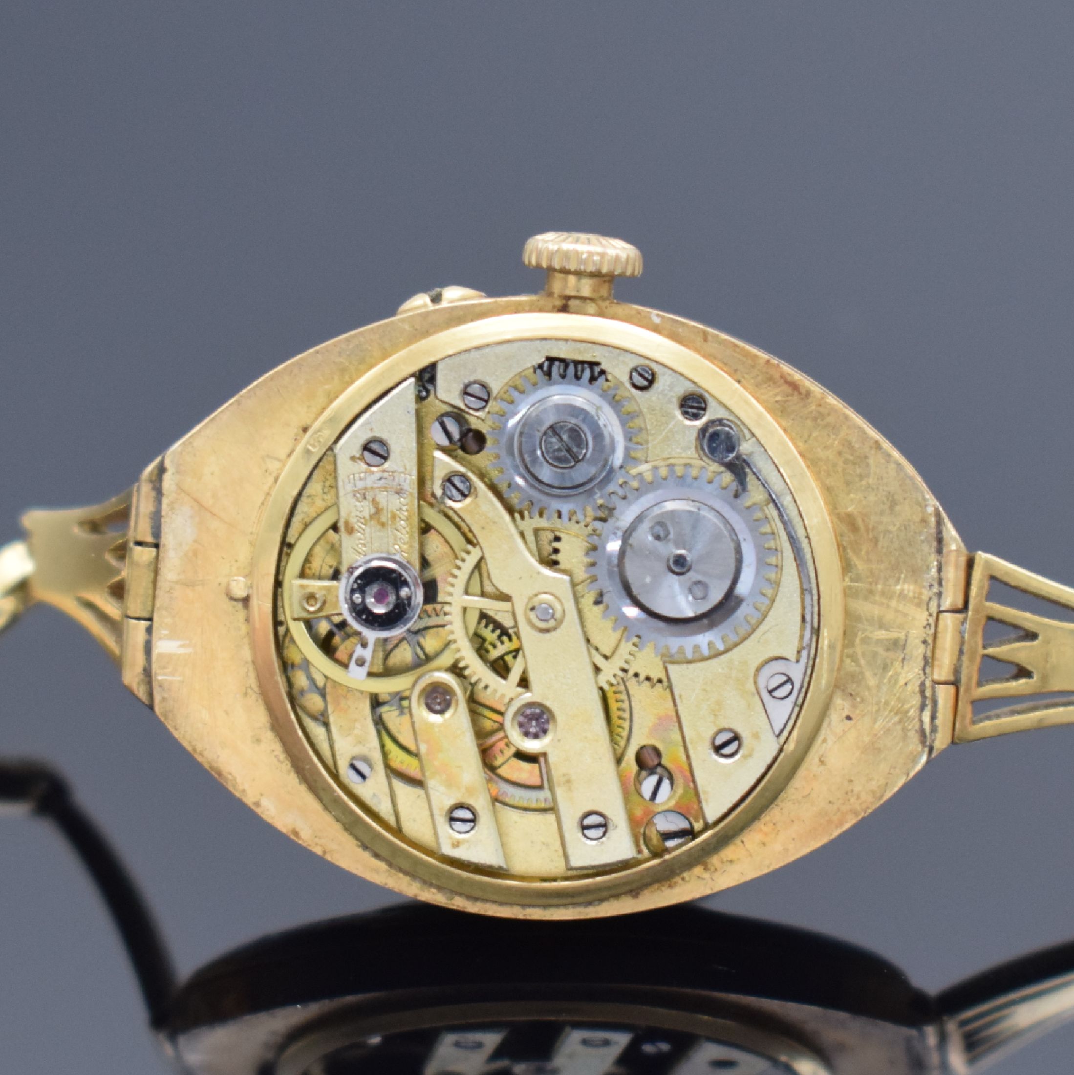 Detail e: Emaillierte Armbanduhr in GG 750/000, Schweiz um 1900, Handaufzug, Geh. & aufgedr. Boden dell., GG 750/000 Band, gold. Zifferbl. altersbed. pat./fl., ...