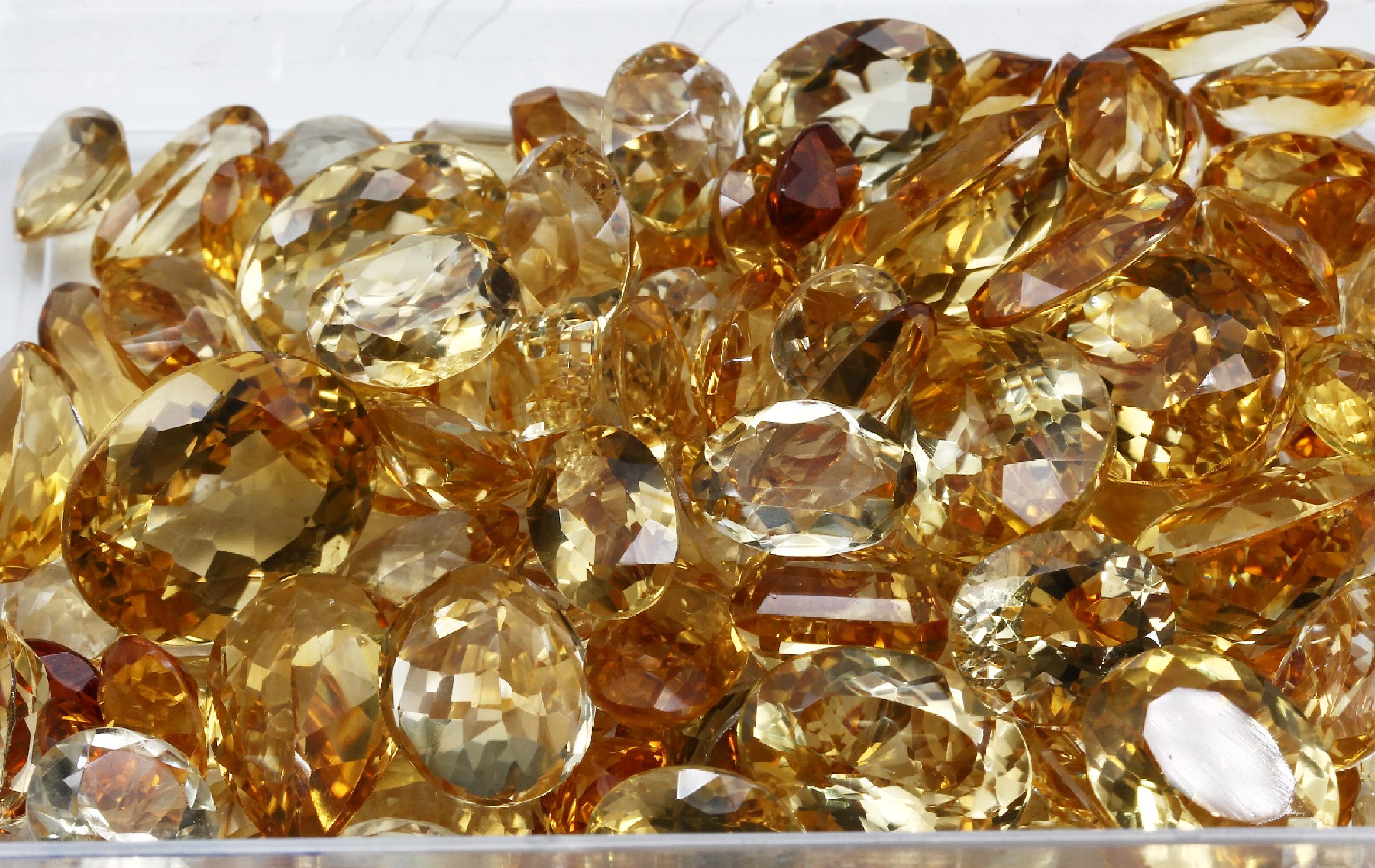 Detail a: Lot lose Citrine total ca. 397 ct, Schleifarbeit aus Idar-Oberstein, versch. Größen und Schliffformen, hauptsächlich rund- und ovalfacett.