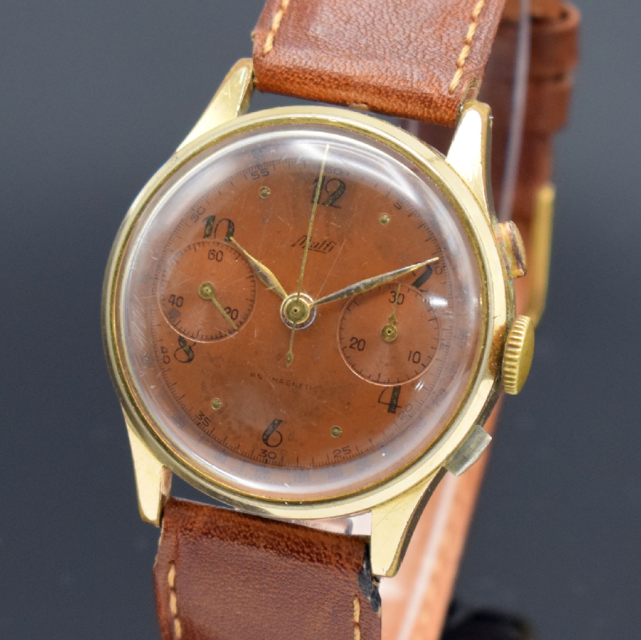 Detail a: MULFI Herrenarmbanduhr mit Chronograph, Schweiz um 1950, Handaufzug, verg. Gehäuse, Stahlboden aufgedr., braunes Zifferbl. altersbed. fl./pat., ...