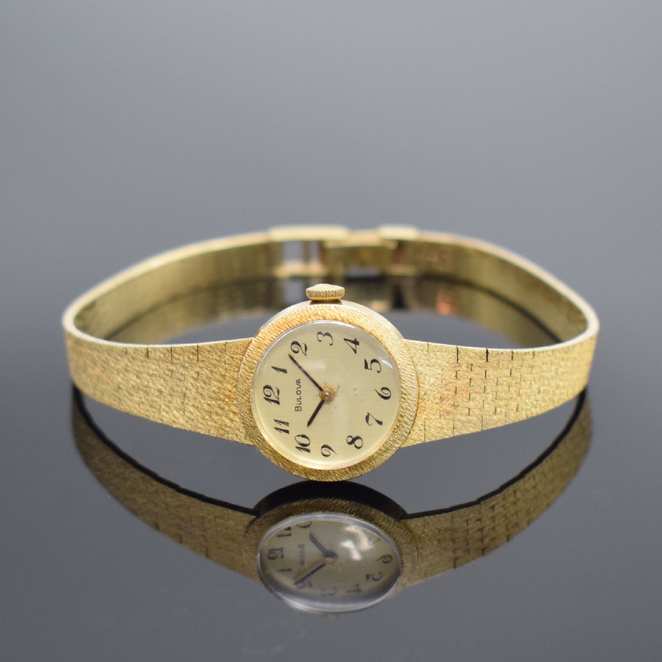 BULOVA Damenarmbanduhr in GG 585/000, Schweiz um 1970, Handaufzug, Geh. an Goldband in 585/000, Boden aufgedr., champagnerfarb. Zifferbl. m. arab. ...