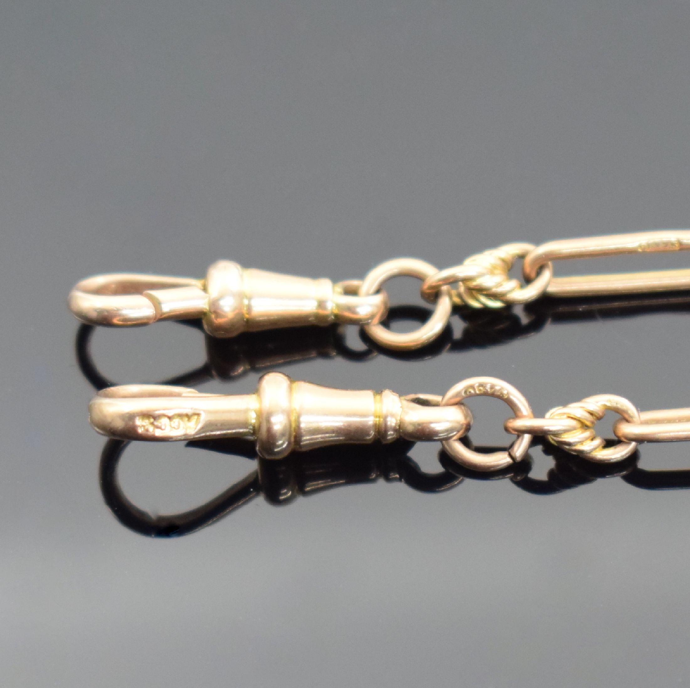 Detail d: 2 Taschenuhrketten in RoseG 375/000, England um 1900, beide m. Knebel & Karabiner, lang- gezogene schmale Glieder einzeln gemarkt, L. ca. 37 & 25 cm, ...