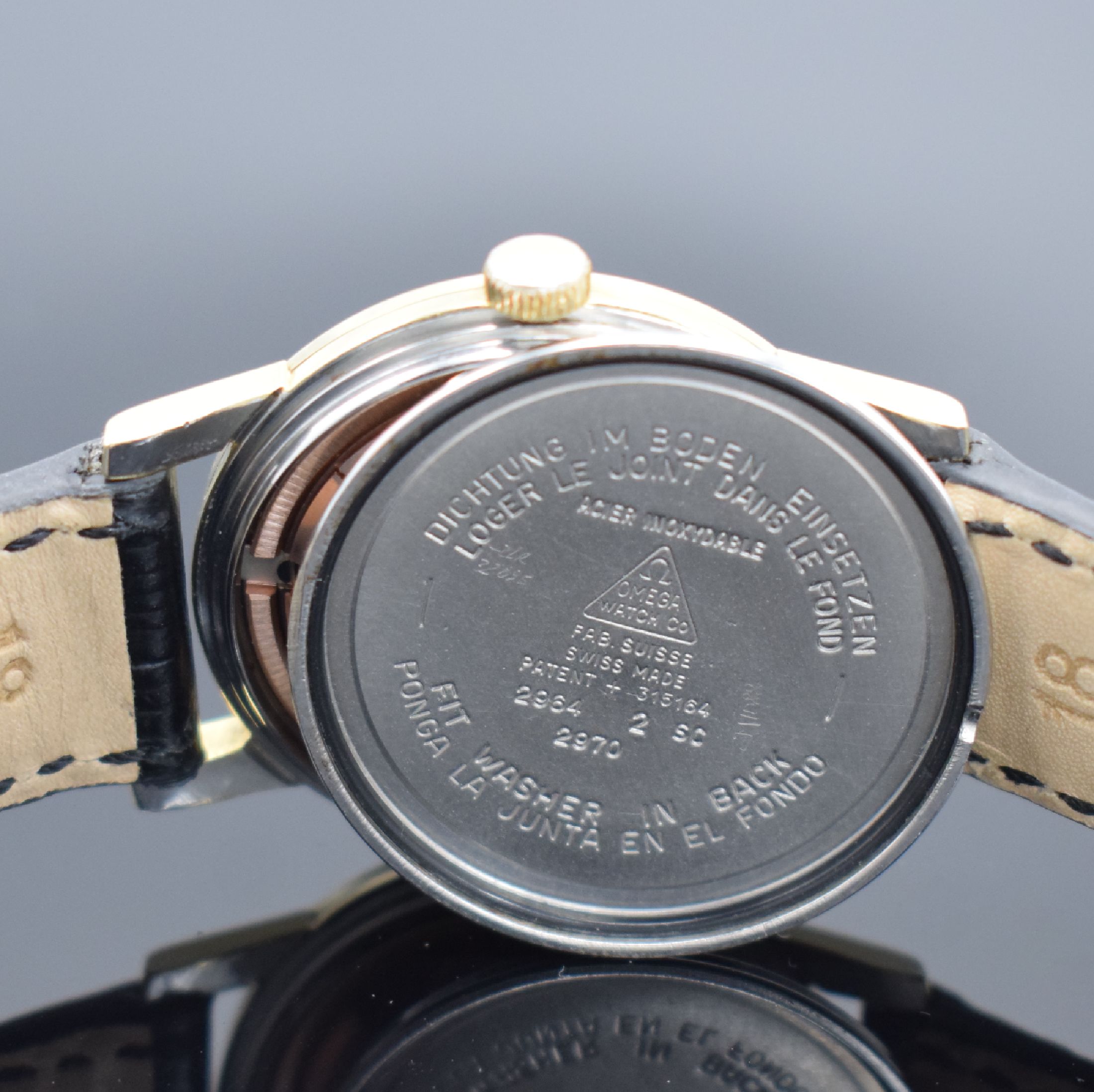 Detail e: OMEGA Seamaster Herrenarmbanduhr, Schweiz um 1961, Handaufzug, Referenz 2964/2970 2 SC, Stahlgehäuse m. Goldhaube, Boden gedr., silb. Zifferbl. m. ...
