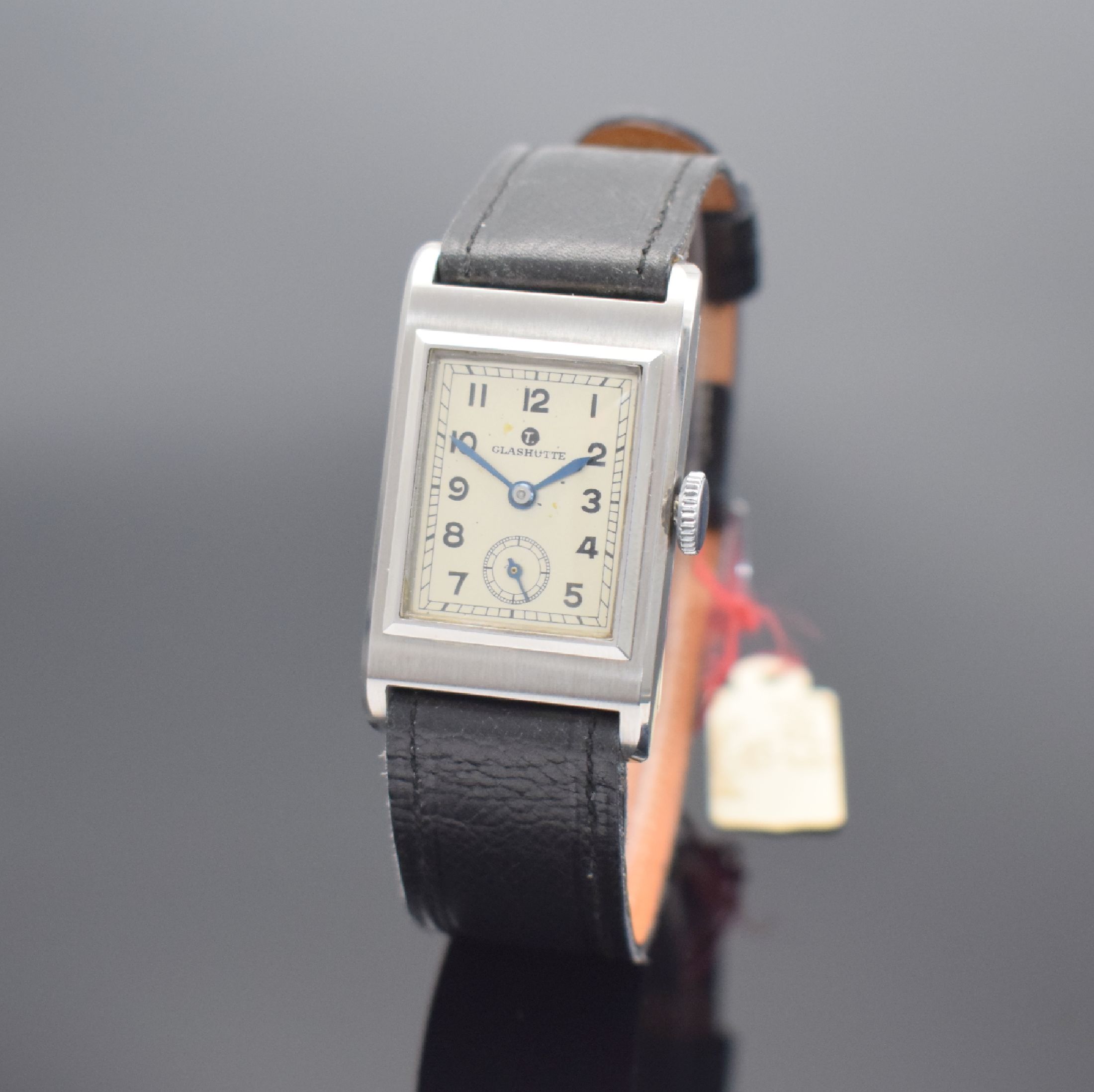 TUTIMA Glashütte / UROFA 58 rechteckige Lagerbestand-Armbanduhr in Stahl, Deutschland um 1935, Scharniergeh. m. Schutzlack auf dem Boden, orig. Band ...