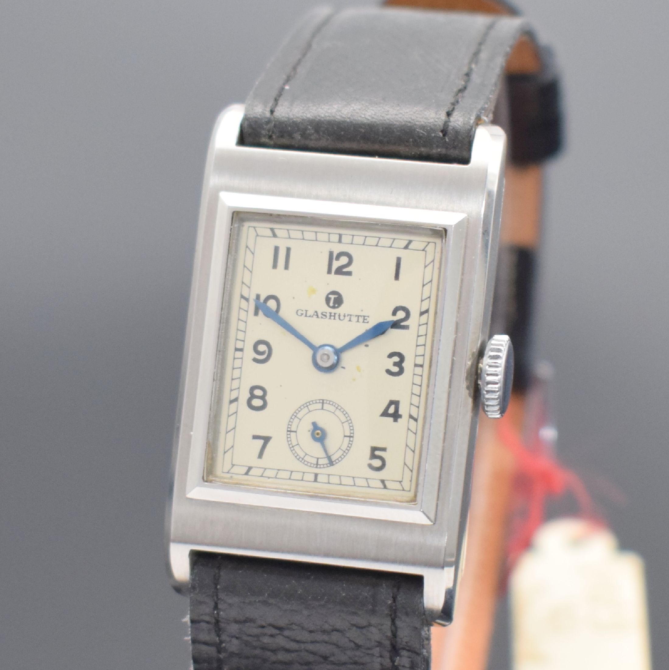 Detail a: TUTIMA Glashütte / UROFA 58 rechteckige Lagerbestand-Armbanduhr in Stahl, Deutschland um 1935, Scharniergeh. m. Schutzlack auf dem Boden, orig. Band ...