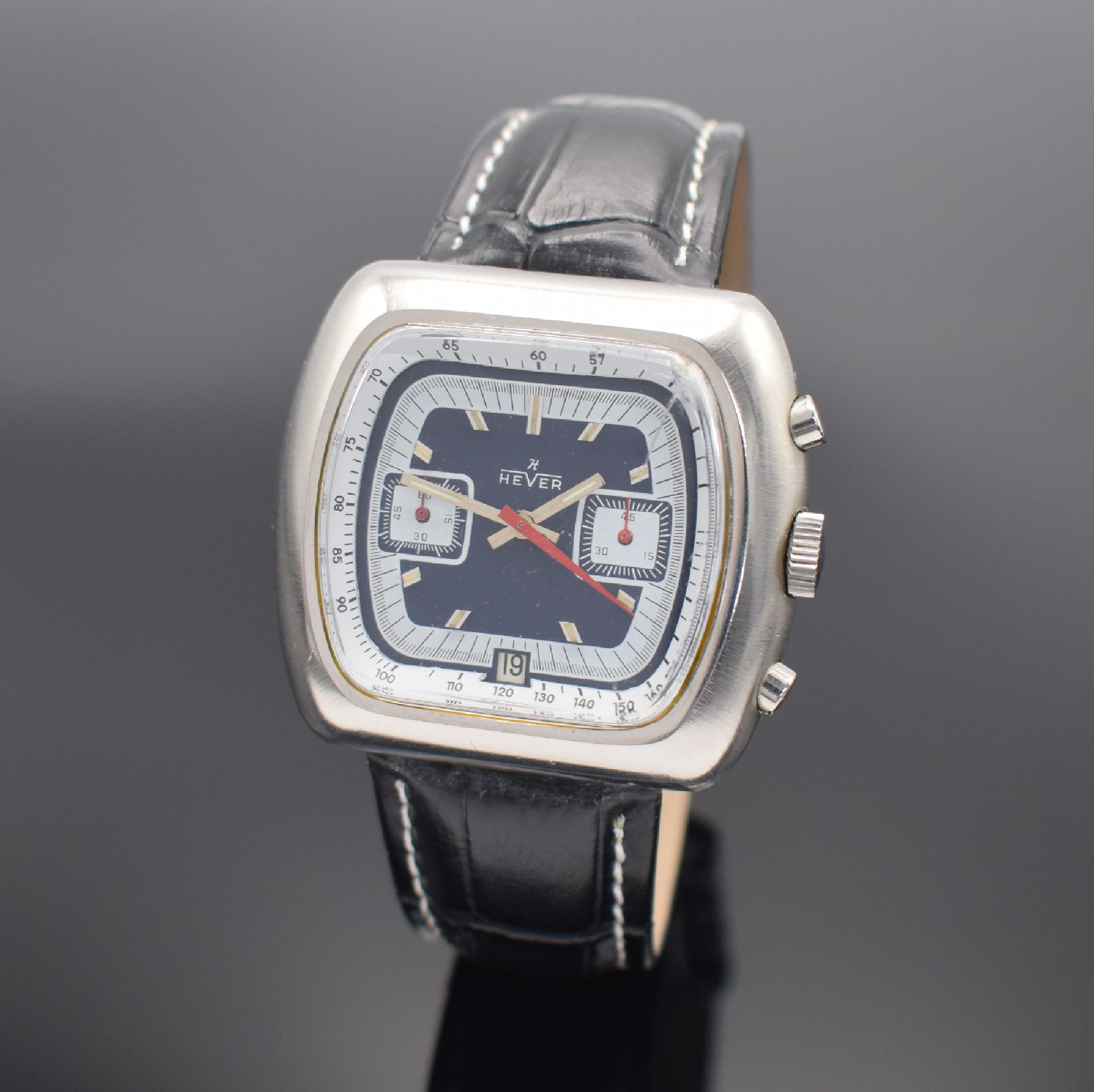 HEVER Herrenarmbanduhr mit Chronograph, Schweiz um 1970, Handaufzug, Edelstahlgeh., Boden geschr., 2-farb. Zifferbl. m. aufges. Std.-Ind., silb. & ...