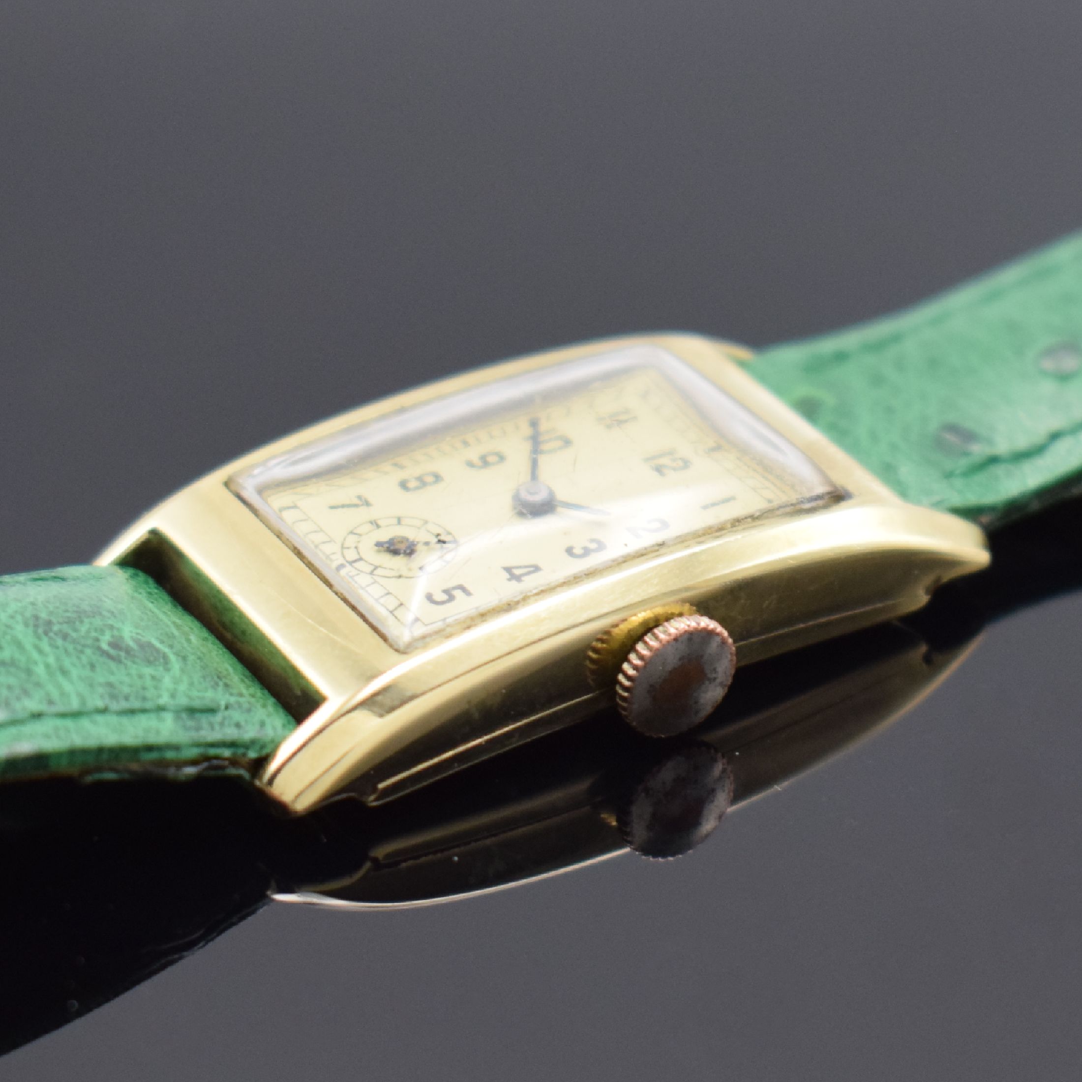 Detail b: Armbanduhr in GG 585/000, Schweiz um 1930, Handaufzug, Scharnierboden, verg. Krone (teils verg. fehl.), champagnerfarb. Zifferbl. m. arab. Zahlen, ...