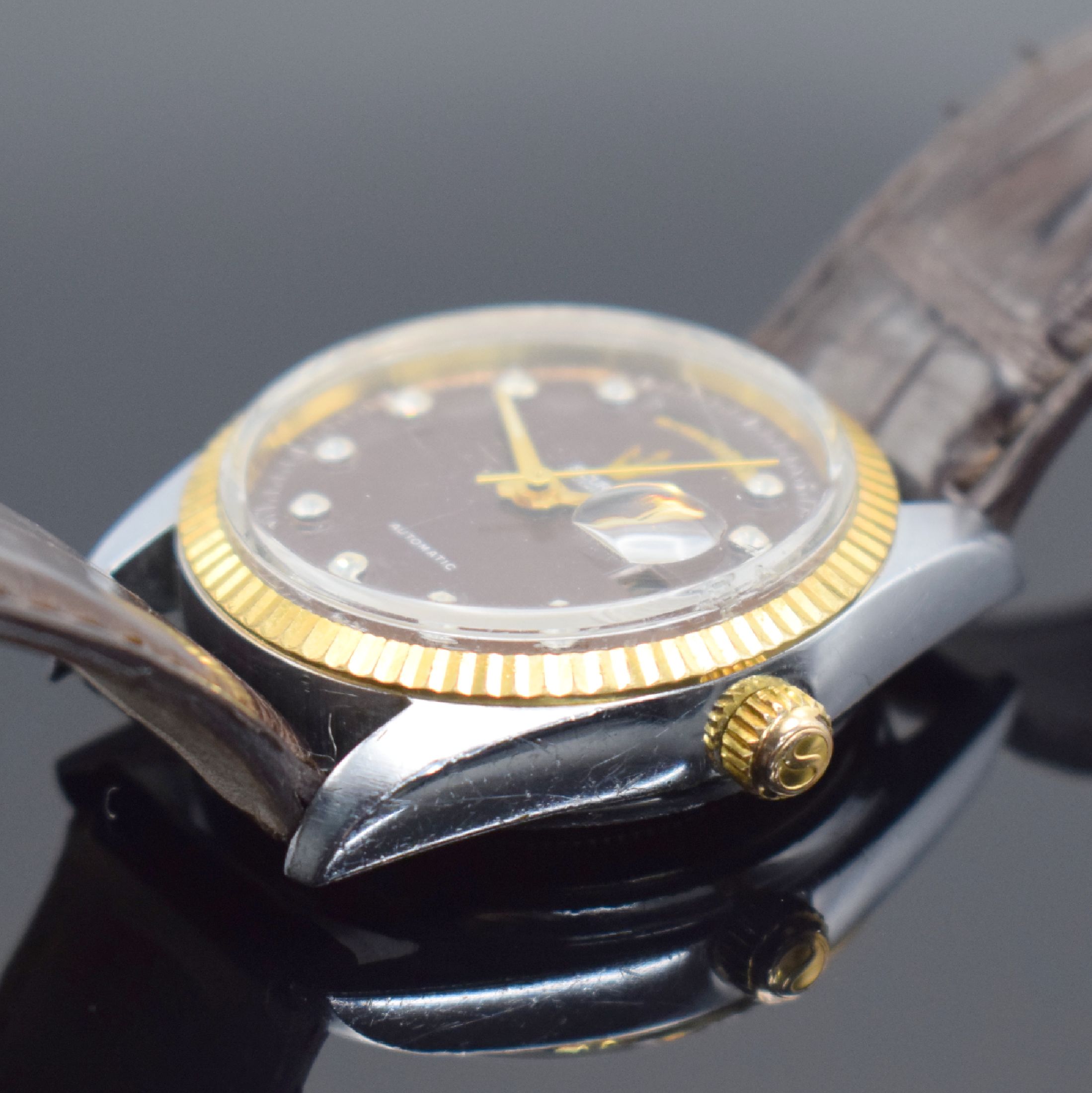 Detail b: SICURA Herrenarmbanduhr Day-Date, Schweiz um 1975, verchr. Geh., Stahlboden verschr., geriffelte Lünette verg., bordeaux-farb. Zifferbl. m. gold. ...
