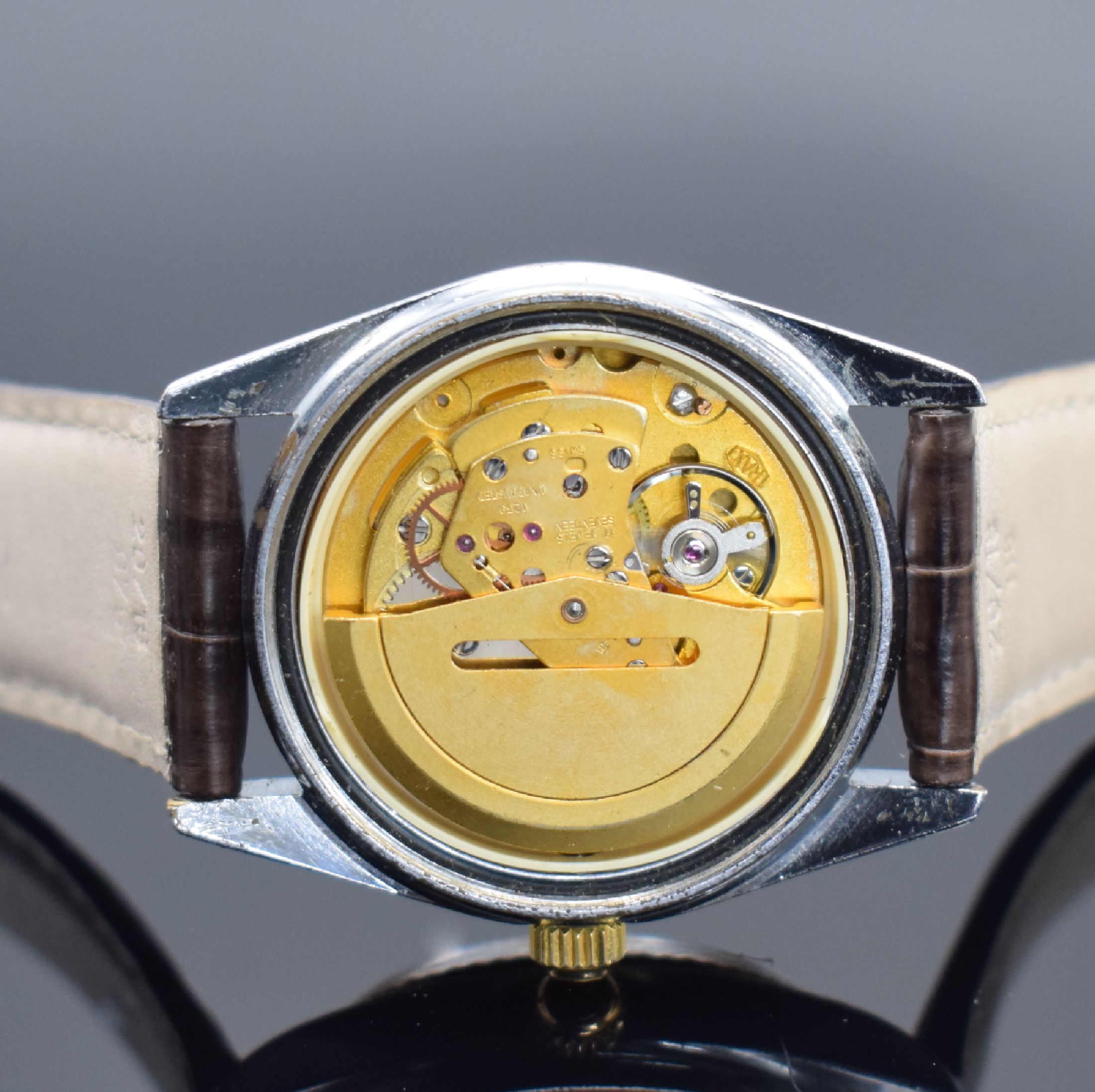 Detail e: SICURA Herrenarmbanduhr Day-Date, Schweiz um 1975, verchr. Geh., Stahlboden verschr., geriffelte Lünette verg., bordeaux-farb. Zifferbl. m. gold. ...