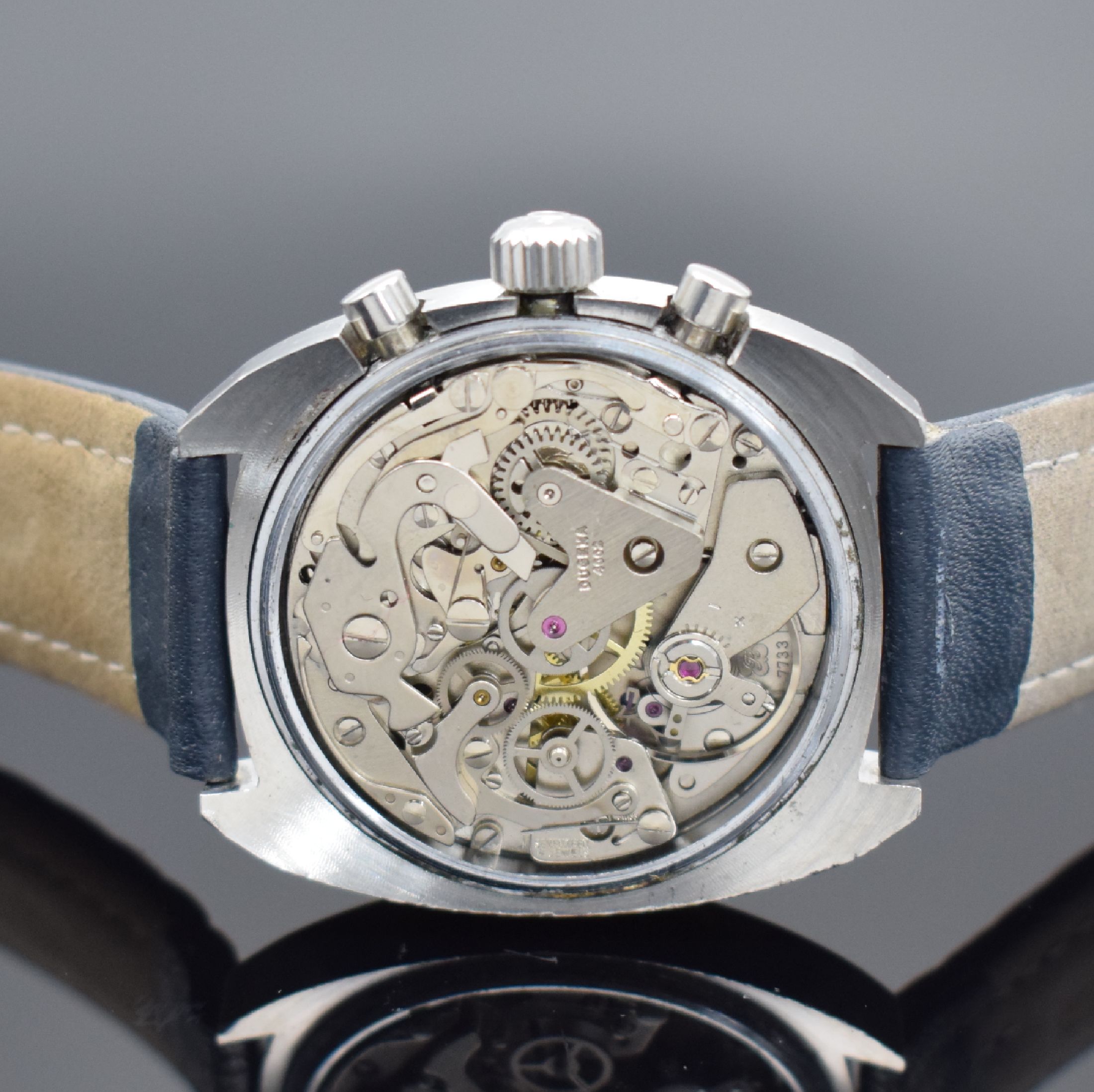 Detail d: DUGENA Herrenchronograph mit Kaliber Valjoux 7733 in Stahl, Schweiz um 1975, Handaufzug, Boden aufgedr., Omega Krone, blaues Zifferbl. m. Leuchtind. ...