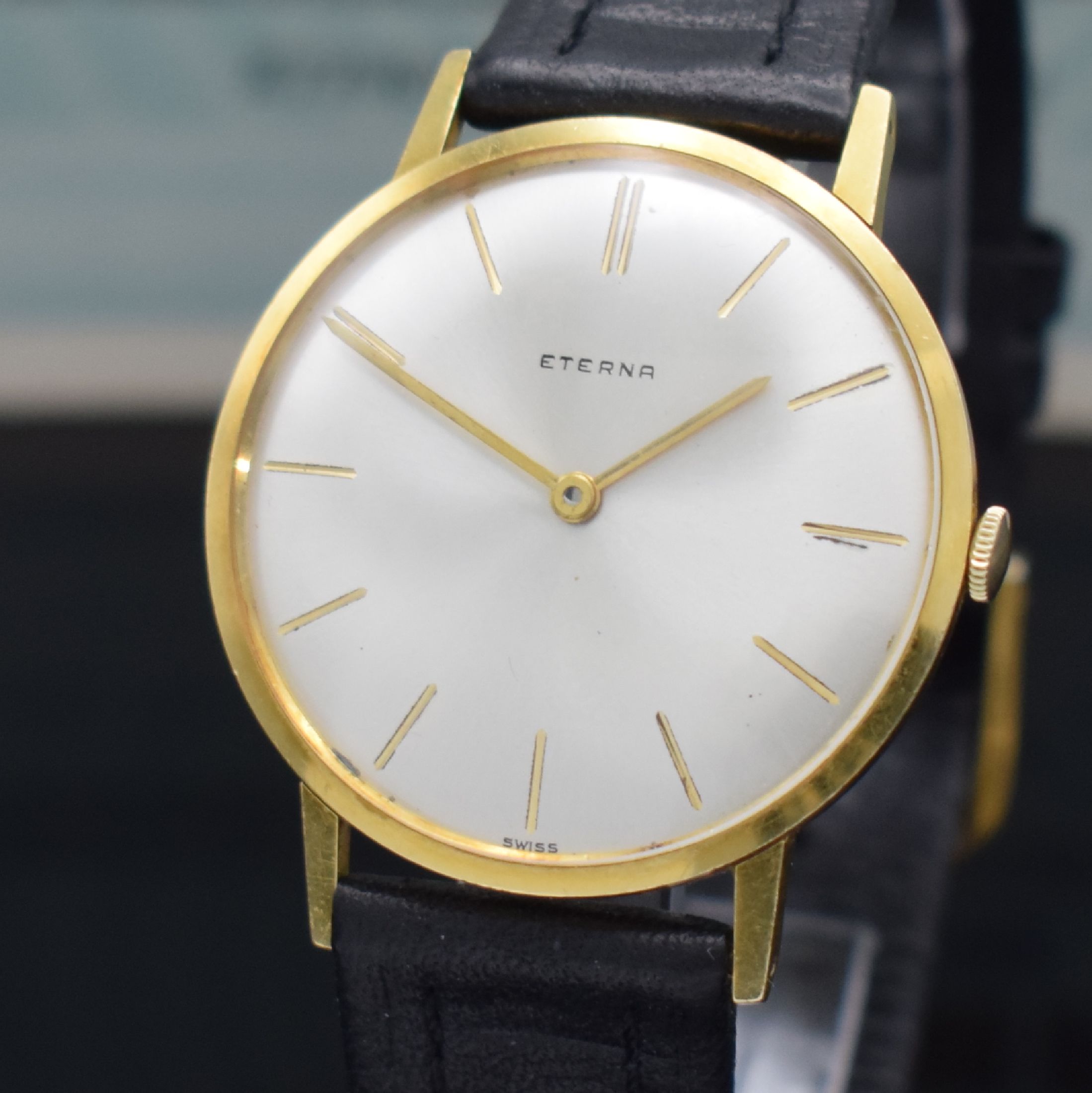 Detail d: ETERNA Herrenarmbanduhr in GG 750/000 mit original Papier Referenz 744, Schweiz verk. lt. Papier 1964, Handaufzug, flaches Geh., Boden & Glasrand ...