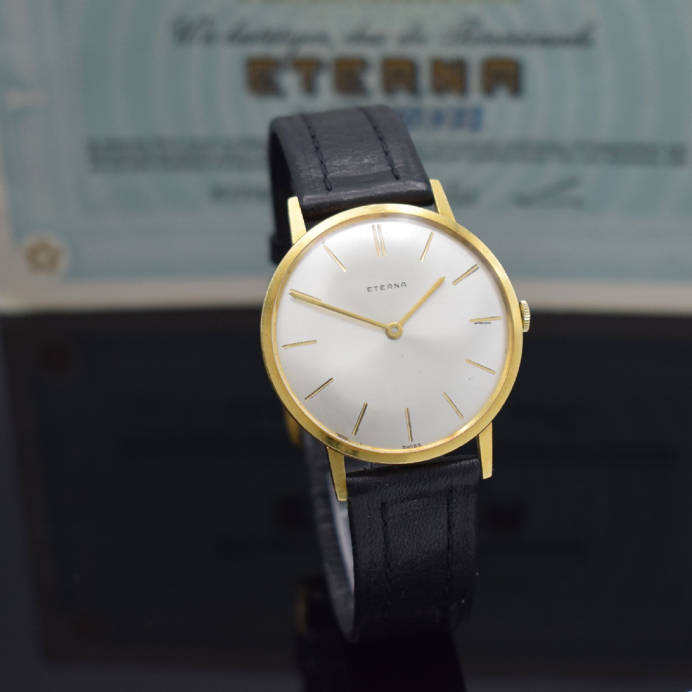 Detail e: ETERNA Herrenarmbanduhr in GG 750/000 mit original Papier Referenz 744, Schweiz verk. lt. Papier 1964, Handaufzug, flaches Geh., Boden & Glasrand ...