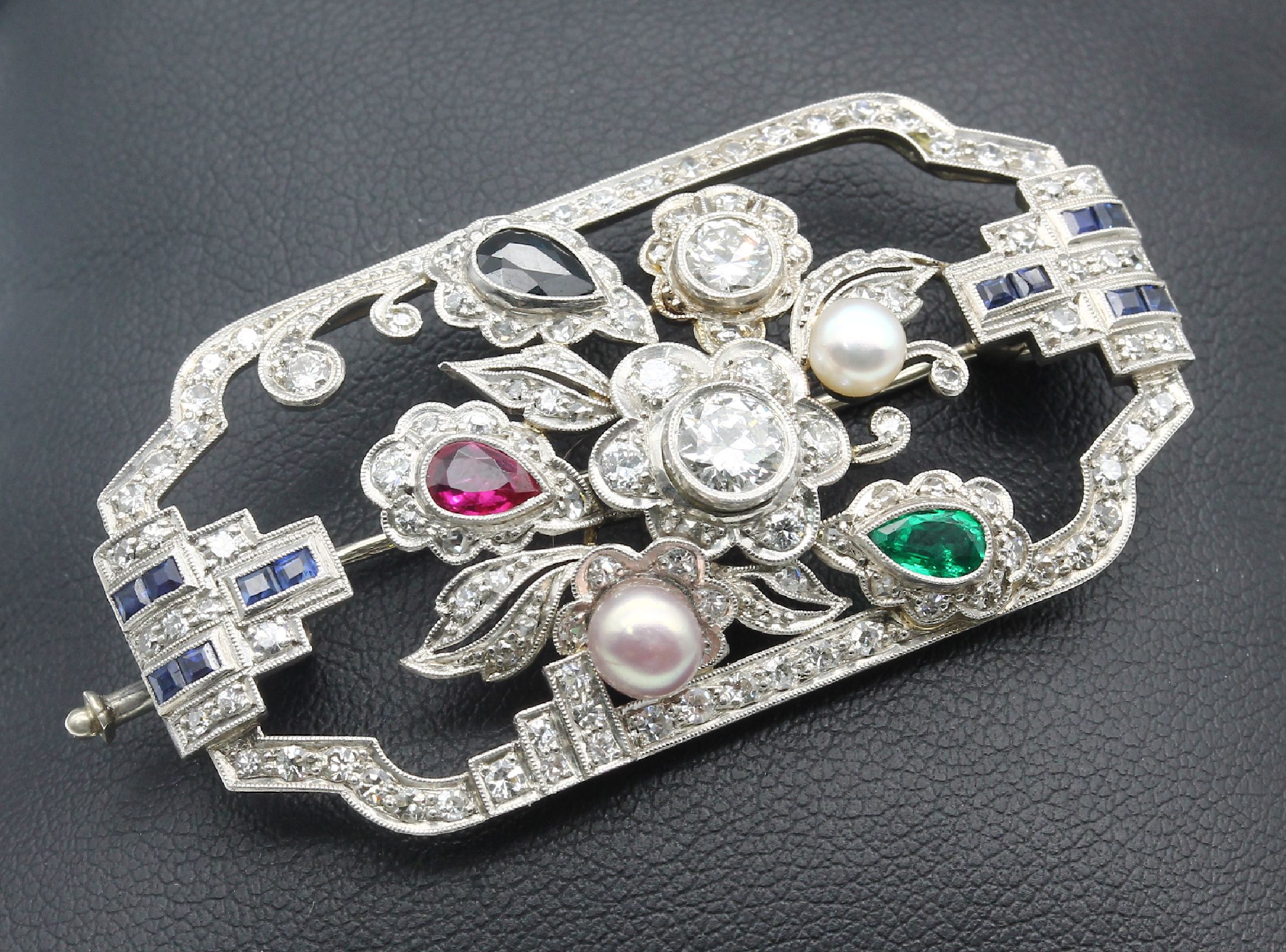 Platin Art-Deco-Brosche, um 1925/30, abstrakt floraler Aufbau, symm. Rahmen, 12 Saphir-Carrees und 1 Saphir-Tropfen zus. ca. 0.31 ct, 1 ...