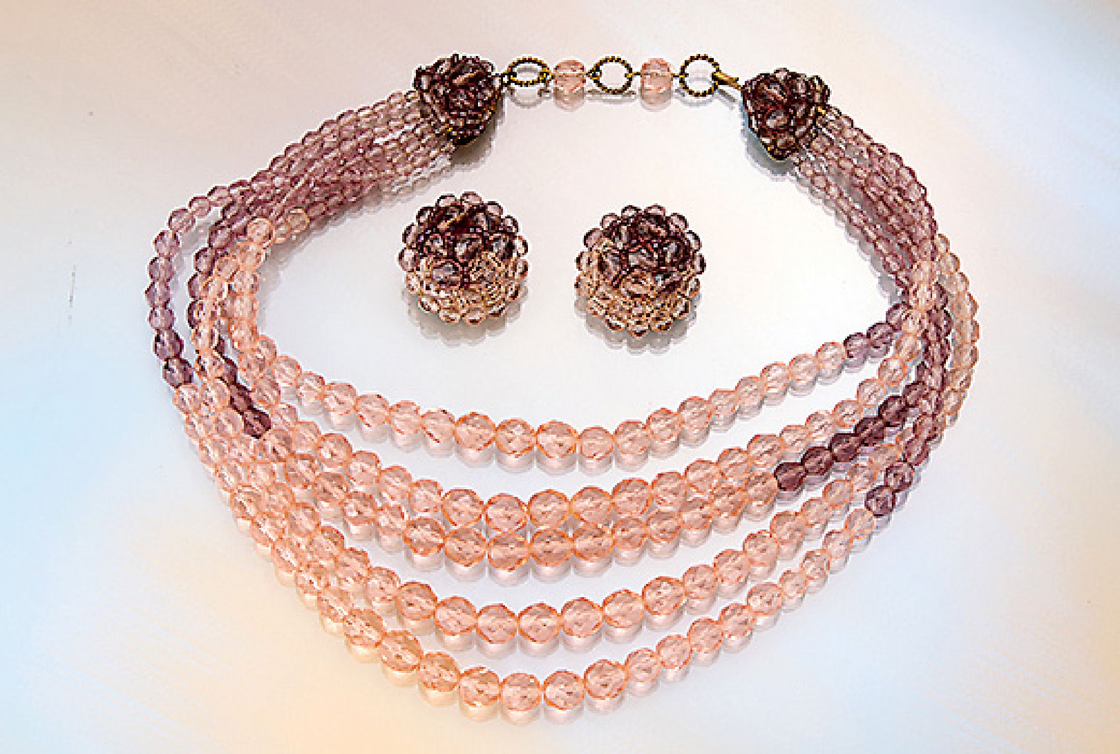 Schmuckset COPPOLA e TOPPO, Italien 1950er Jahre, best. aus: 5-reihigem Collier und Paar Ohrclips, facett. Glasperlen in Rosa und Lila, Ohrclips ...