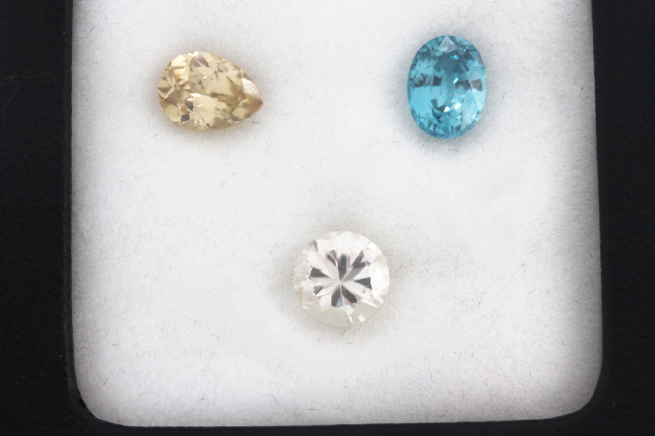 Detail a: Lot 3 lose Zirkone zus. 6.0 ct, 1 x weiß, Brillantschliff, 1 x gelb, Tropfen, 1 x bläulich, ovalfacett.