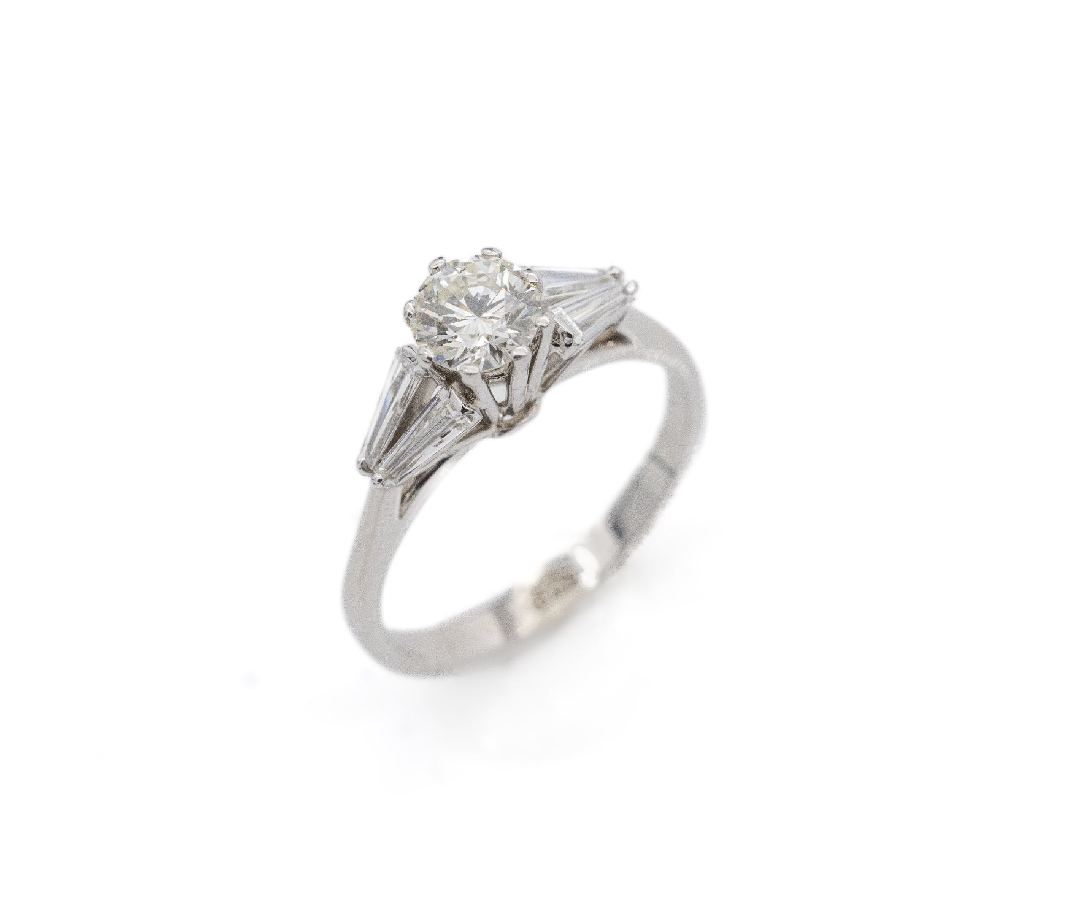 18 kt Gold Diamant-Ring, WG 750/000, 1 Brillant ca. 0.60 ct get. Weiß/si, 4 Diamant -Trapeze zus. ca. 0.50 ct Weiß/ vs, total ca. 1.10 ct get. ...