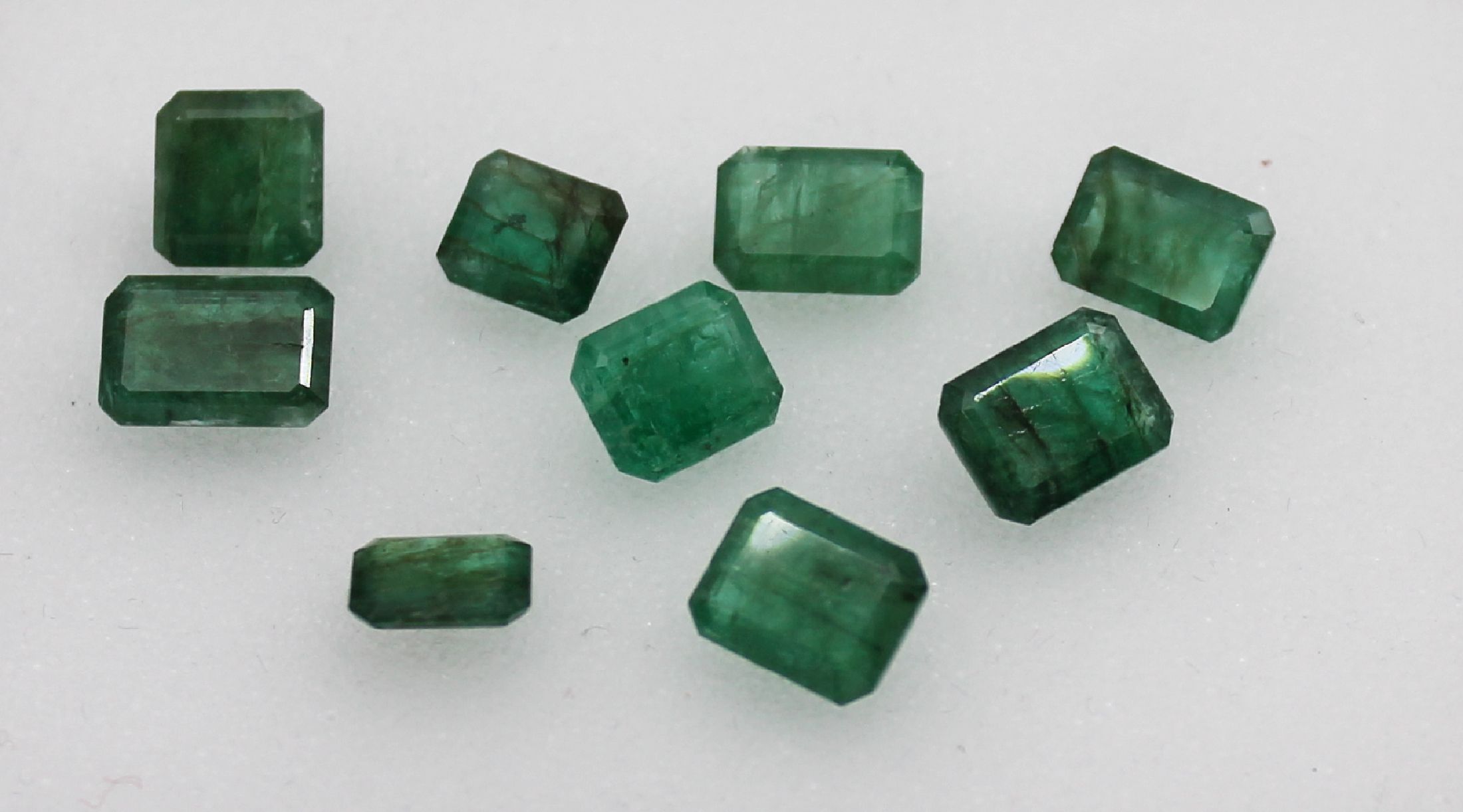 Lot 9 lose Smaragde, zus. ca. 20.68 ct, Treppenschliff in versch. Größen, nat. Merkmale