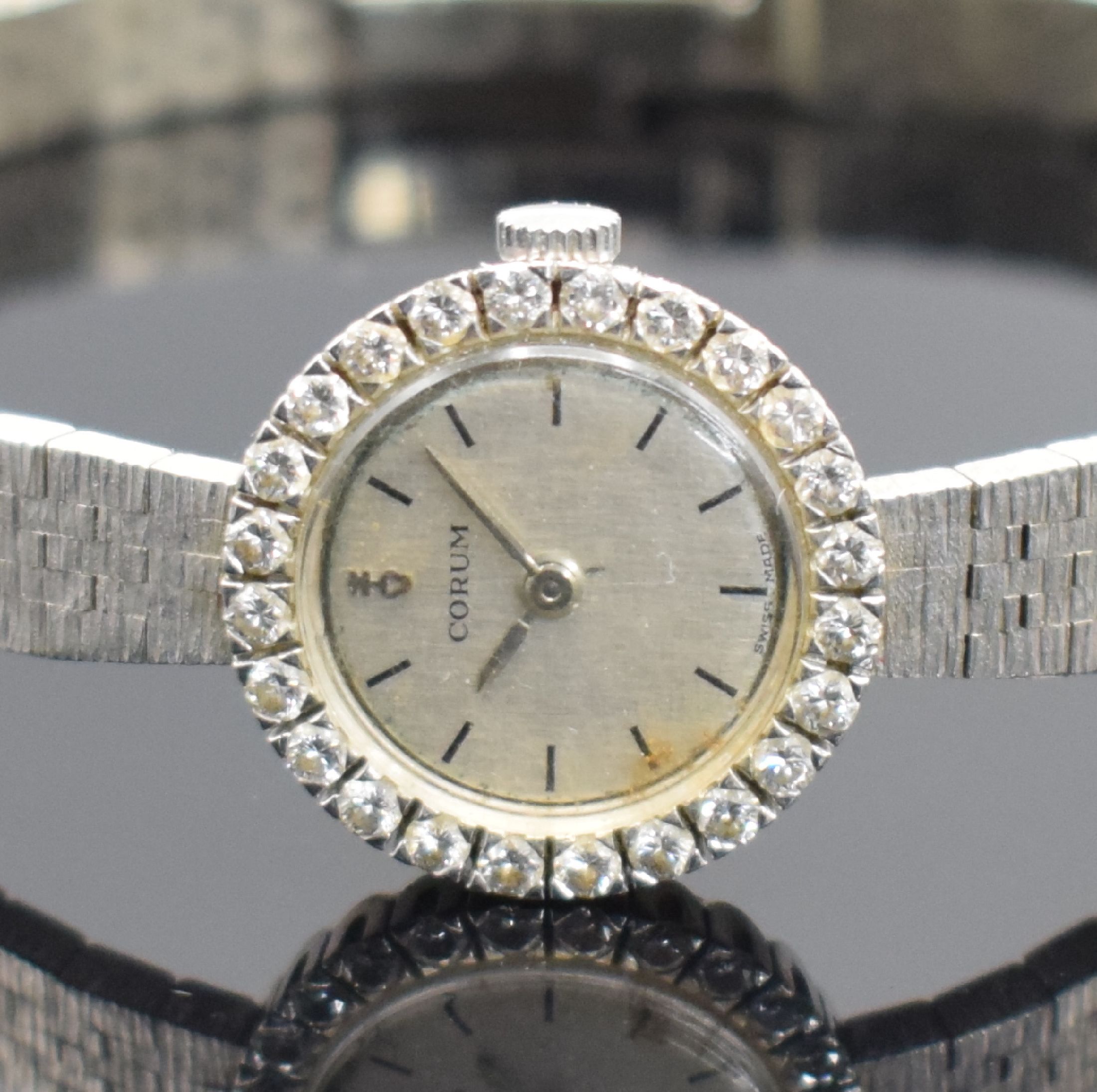 Detail a: CORUM Damenarmbanduhr mit Diamantbesatz in WG 750/000, Schweiz um 1970, Handaufzug, Boden aufgedr., WG 750/000 Band, silb. Strukturzifferbl. m. silb. ...