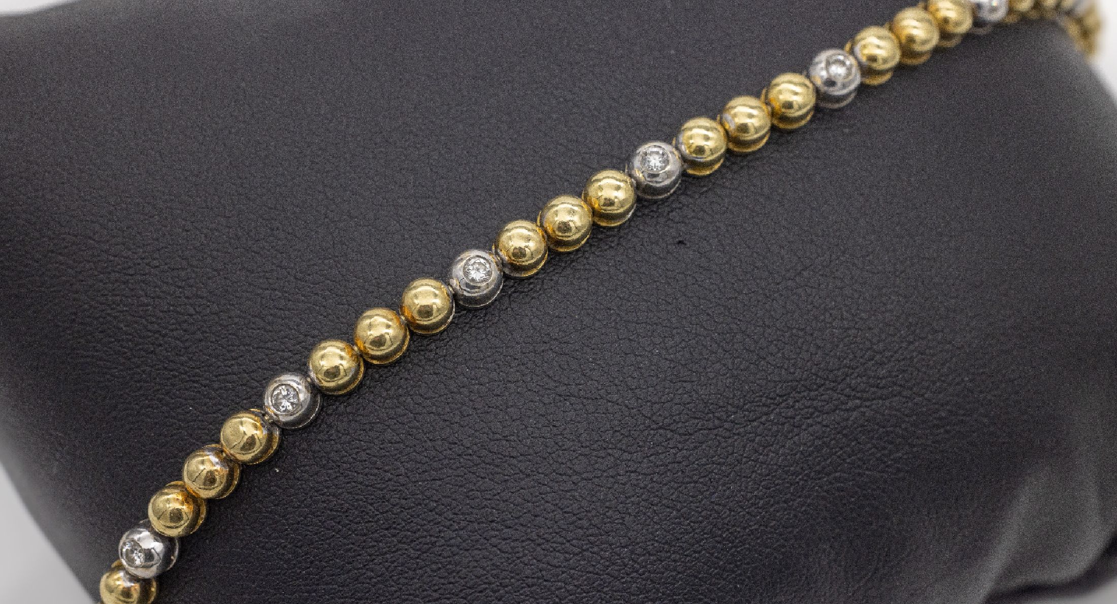 18 kt Gold Brillant-Armband, ca. 17.2 g, GG/WG 750/000, einzelne Halbkugeln, 12 in WG gefasste Brillanten zus. ca. 0.24 ct Weiß/si, L. ca. 19 cm, ...