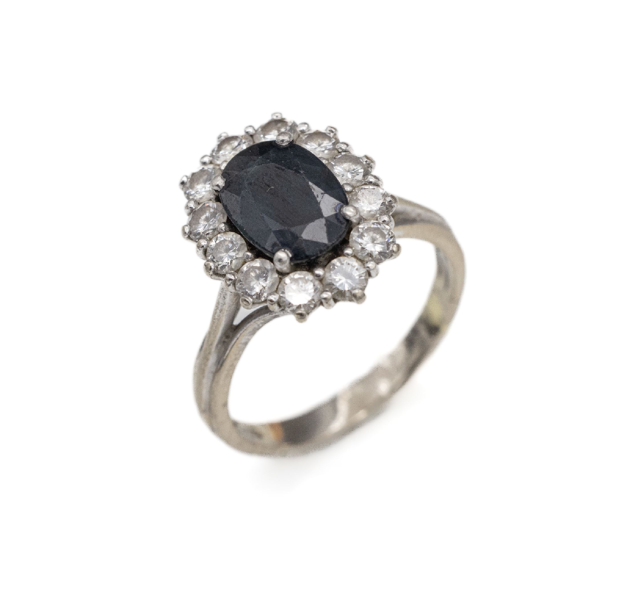 18 kt Gold Saphir-Brillant-Ring, WG 750/000, ovalfacett Saphir ca. 2.00 ct (leichtbesch.), umgeben von 12 Brillanten zus. ca. 0.60 ct Weiß/si, RW ...
